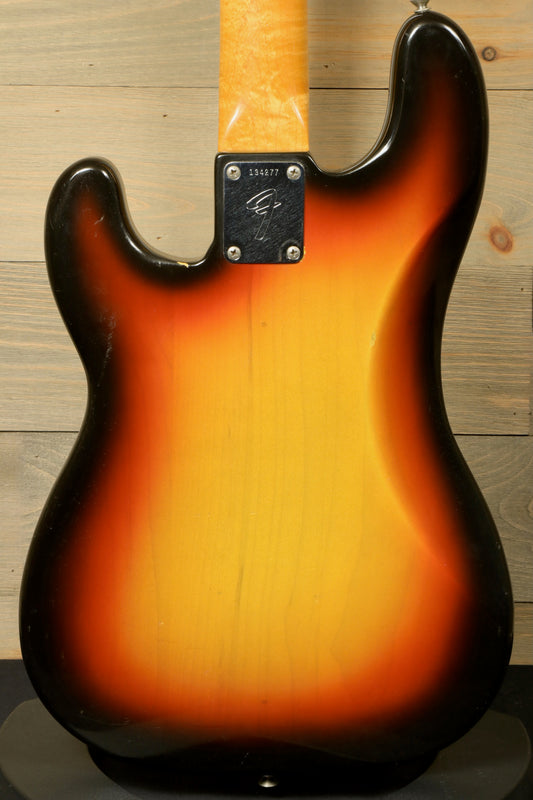 Fender Precision Bass 1966 with Original Case (USED) in a casual setting with musical accessories.