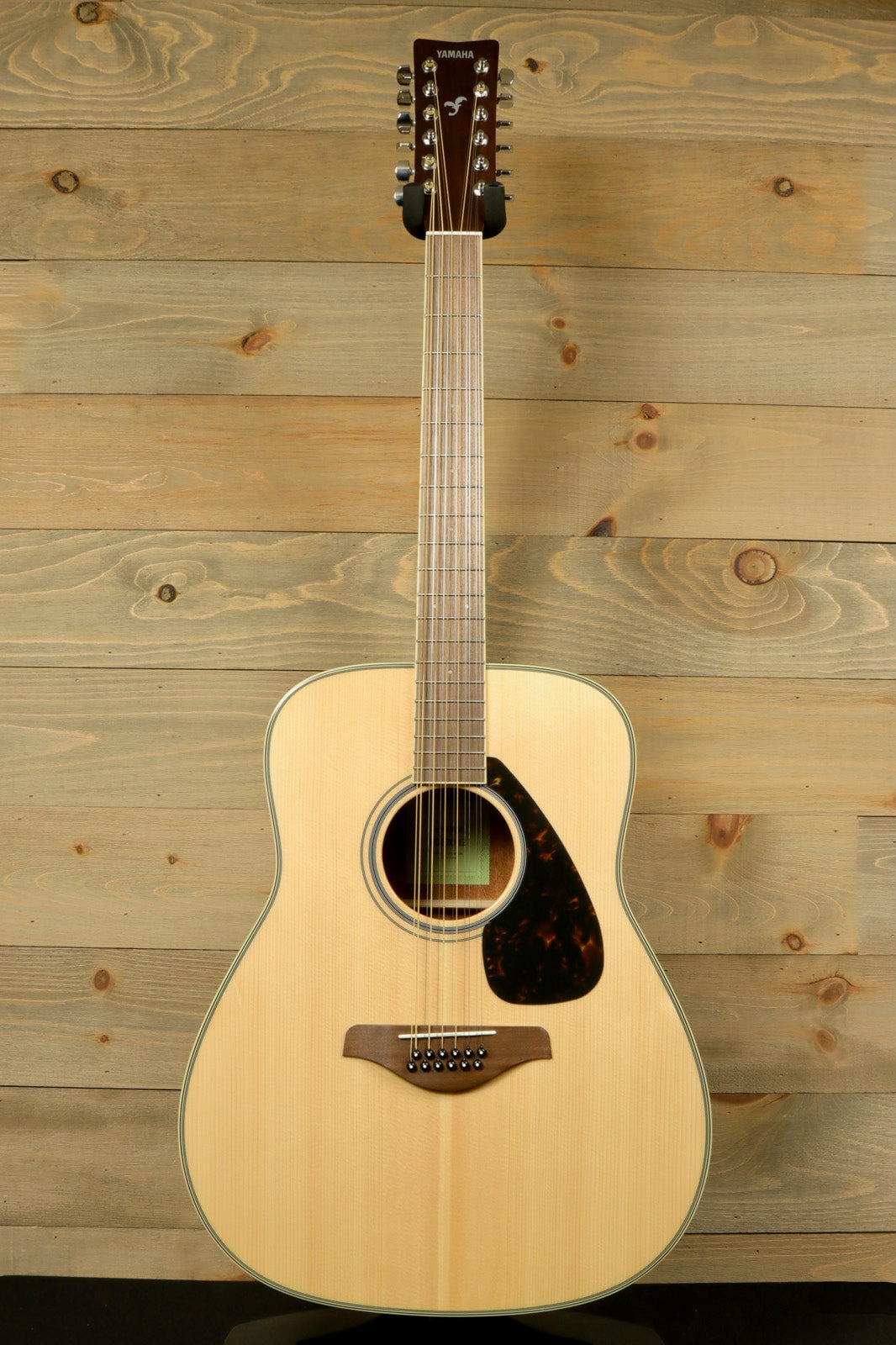 Yamaha acoustic guitar natural finish, front view with tortoiseshell pickguard