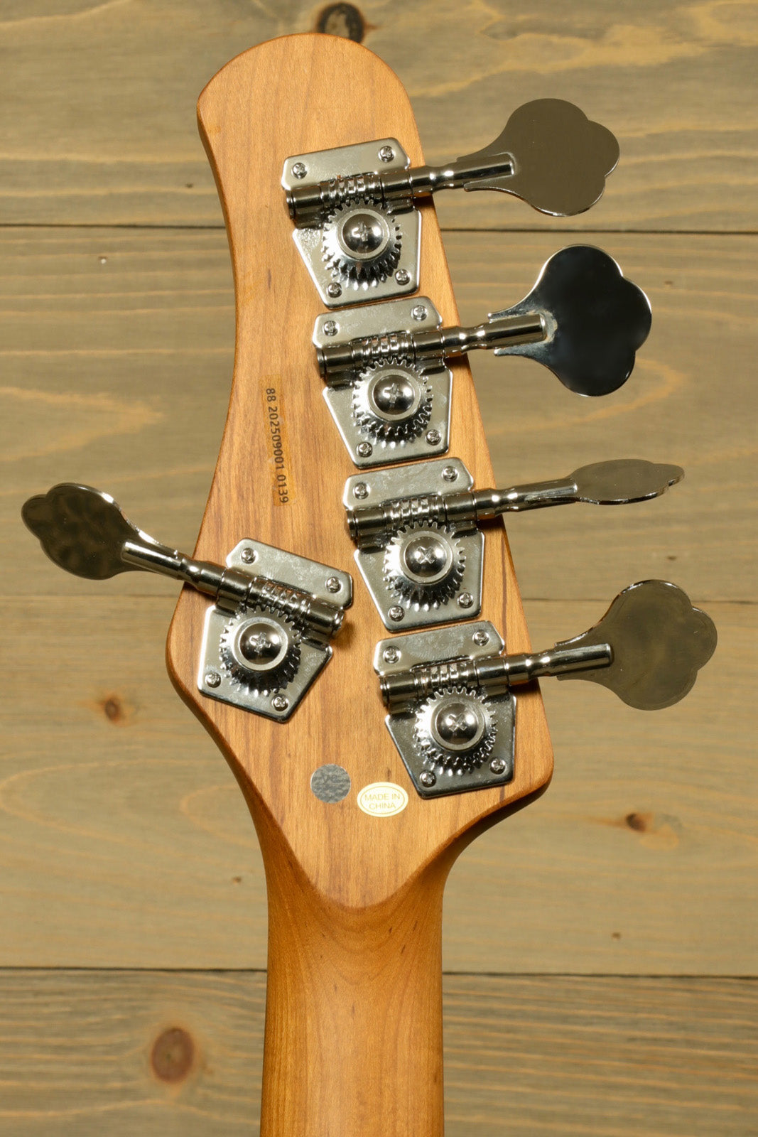 Tagima bass guitar 5 string with chrome tuners on natural wood neck, back view