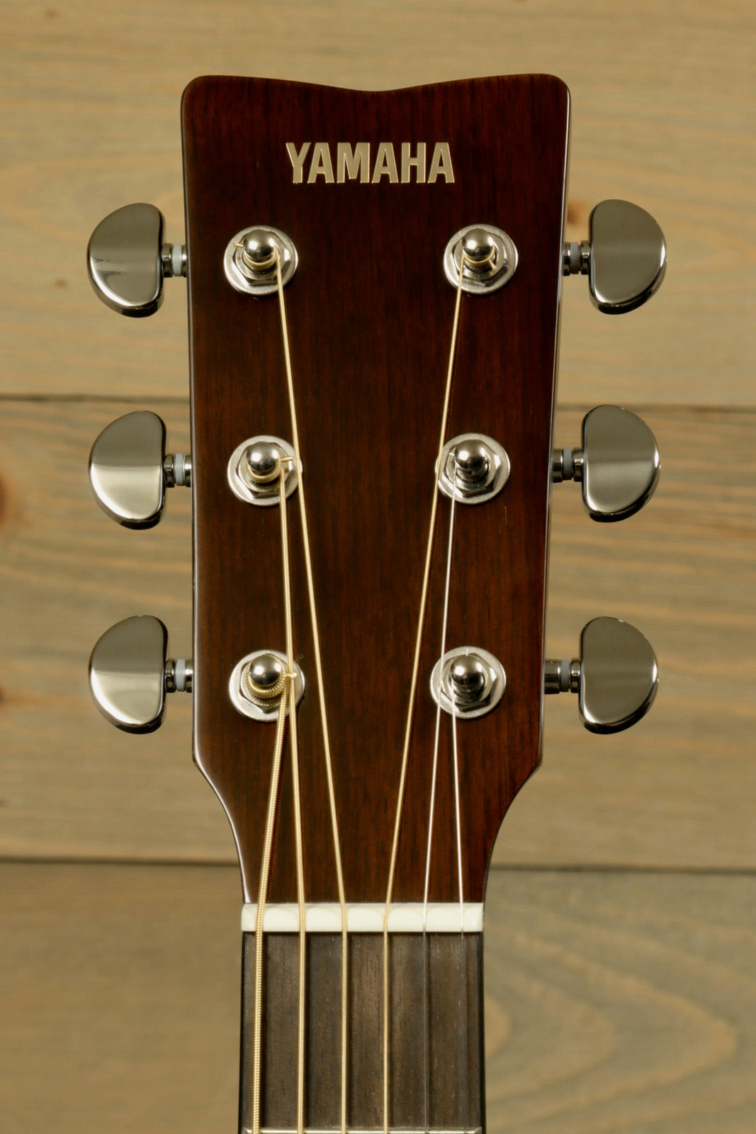 Yamaha acoustic electric guitar, walnut headstock with chrome tuners, front view