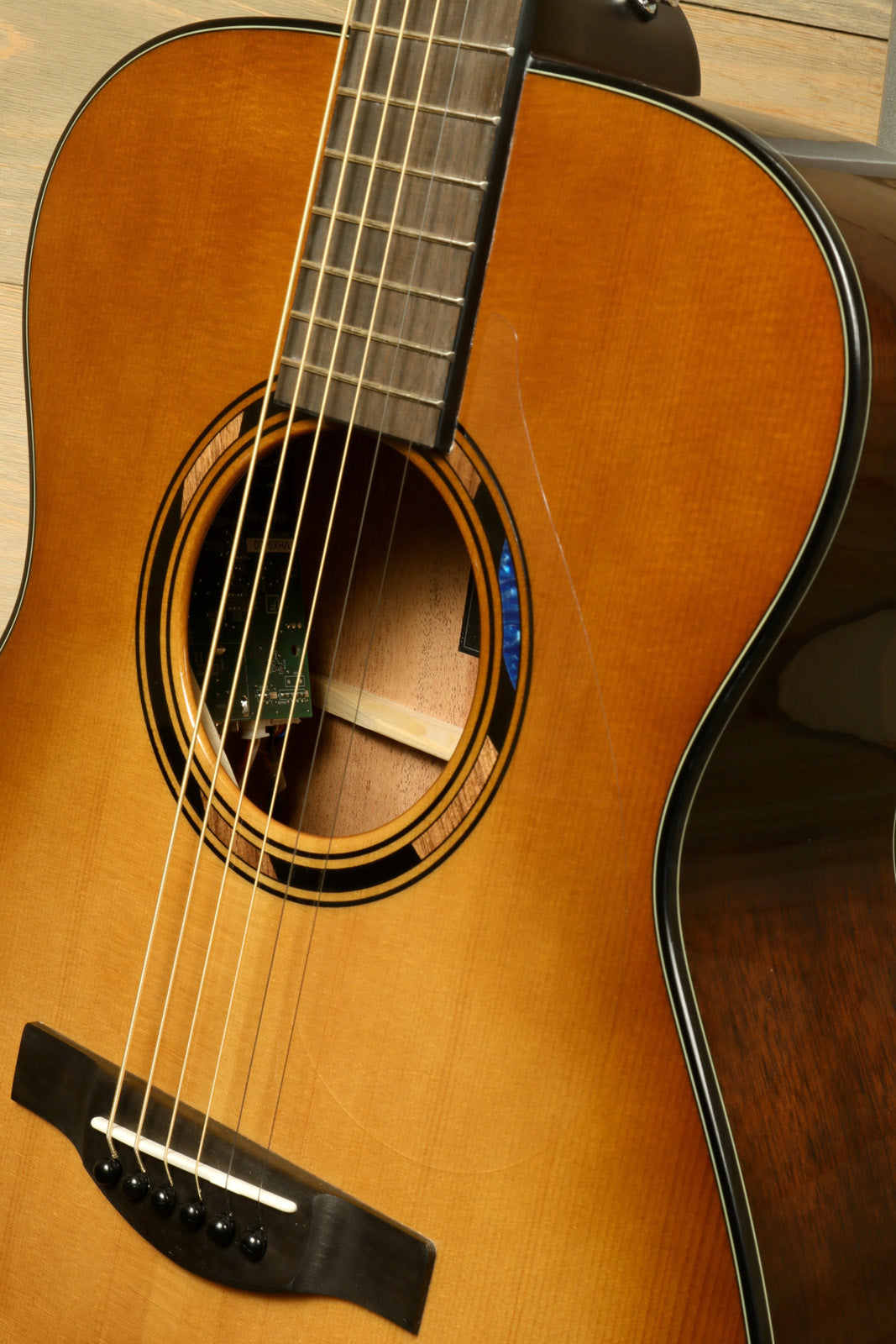 Yamaha acoustic electric guitar, natural finish, close-up view of body and fretboard