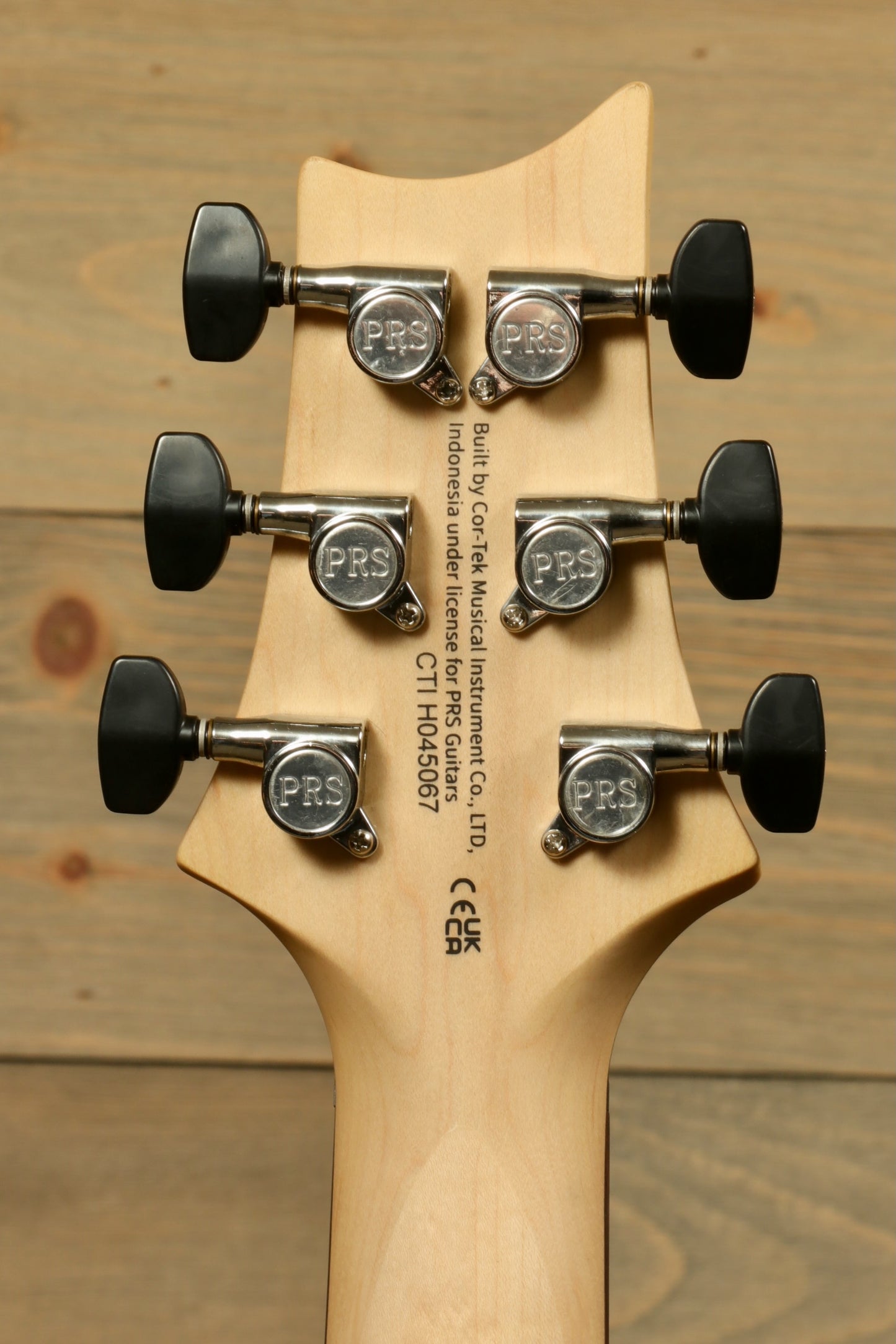 Back view of PRS SE CE24 Standard Stoptail guitar neck with tuning pegs and brand logo