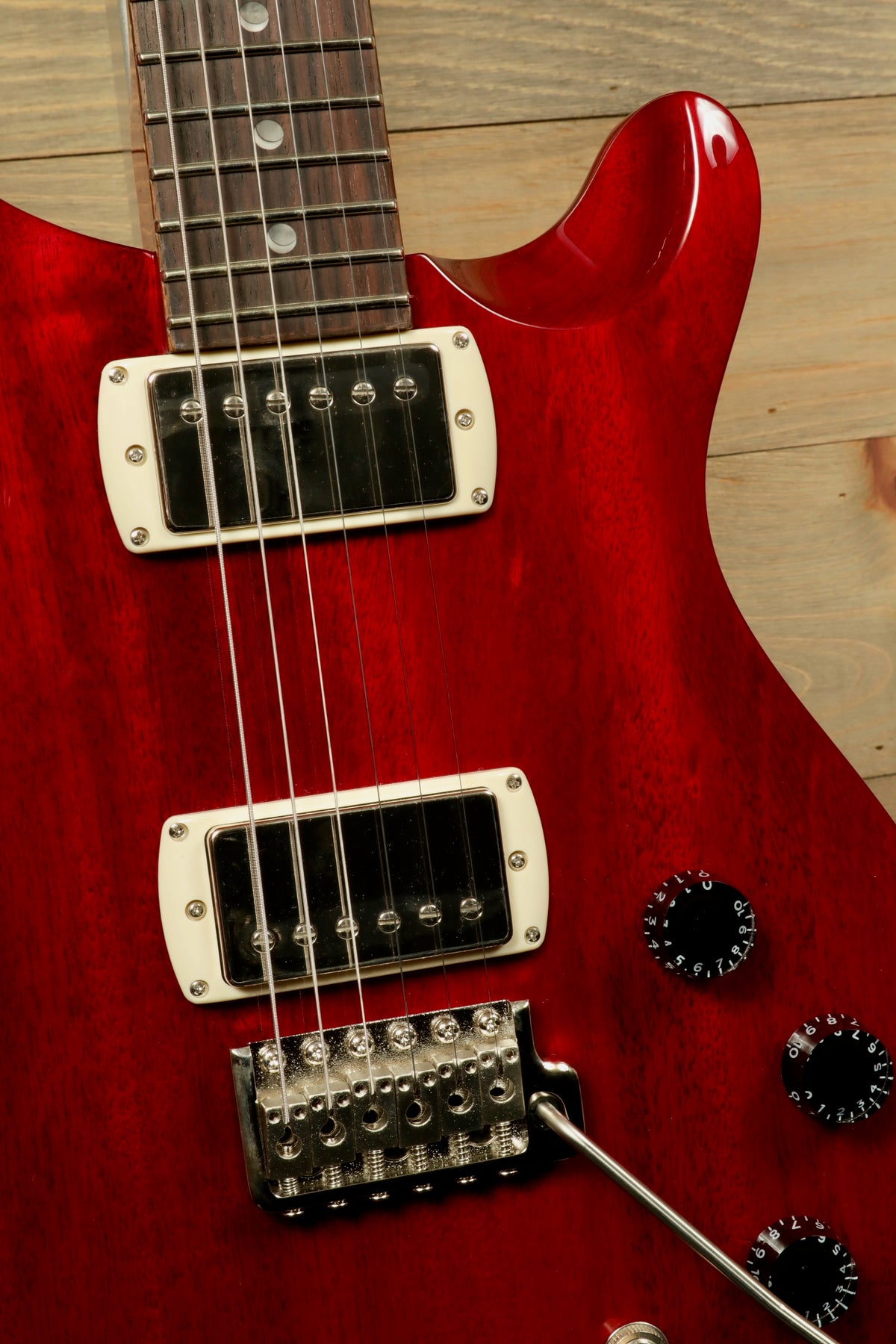 Close-up of PRS SE DGT Standard guitar showcasing the cherry red finish and detailed hardware