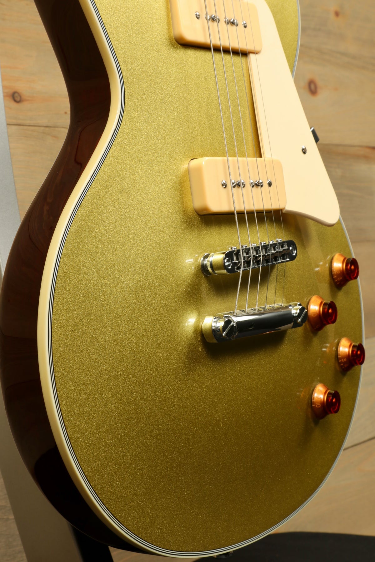 Sire Electric Guitar Goldtop with a shimmering finish, side view highlighting hardware and details.
