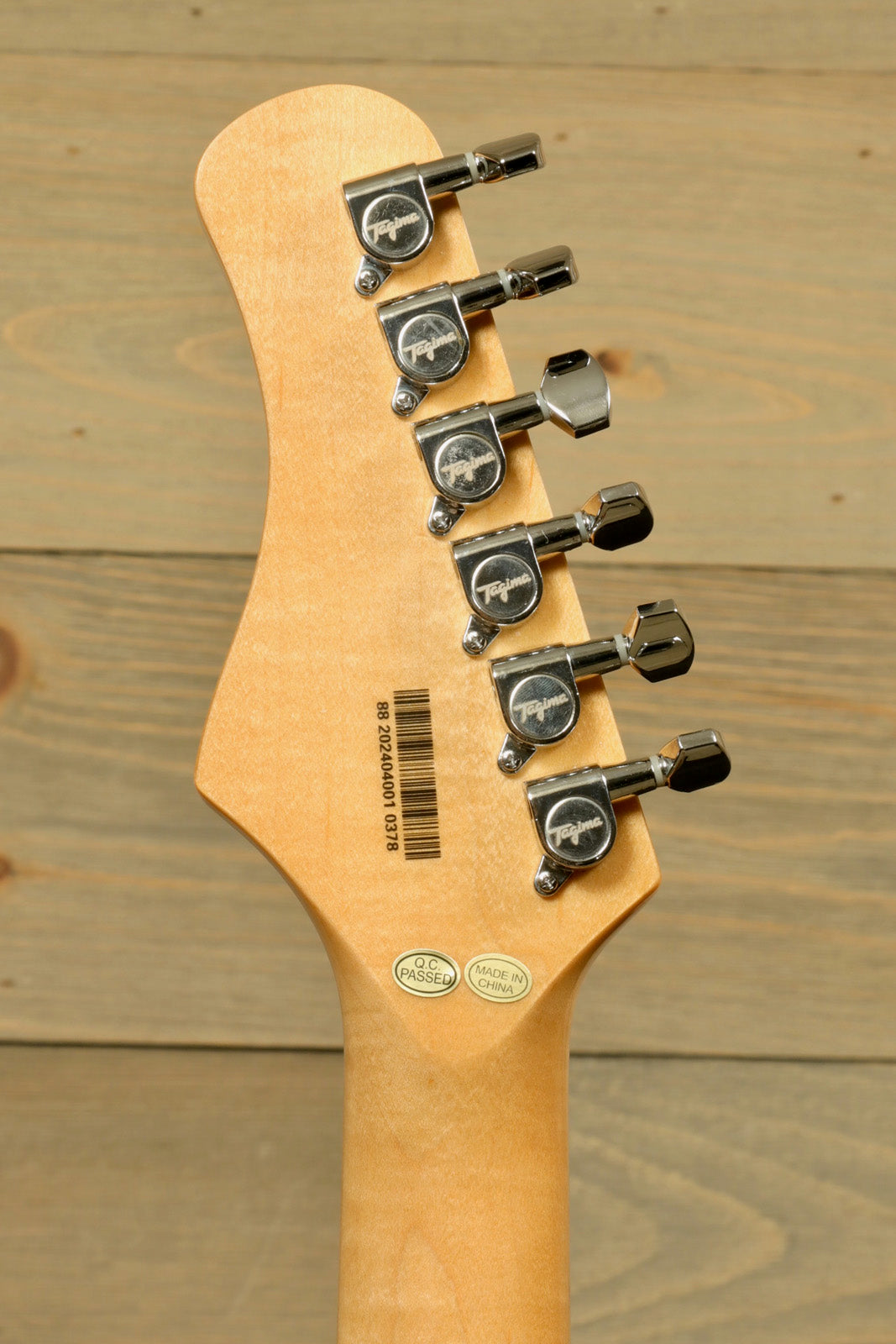 Tagima TG 540 electric guitar headstock showcasing six tuning pegs and natural wood finish
