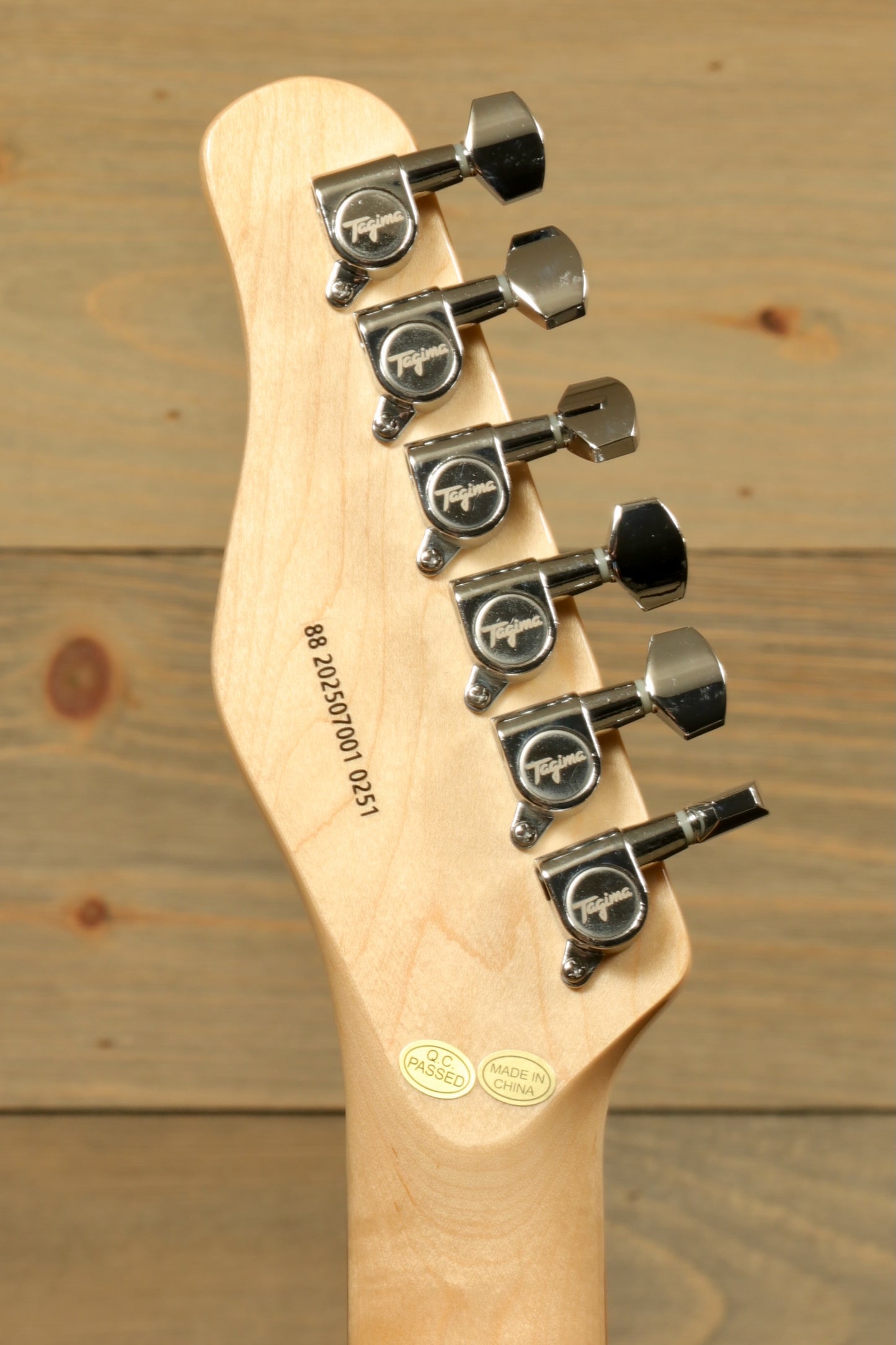 Tagima TW 55 MCBL/BK Electric Guitar headstock, showcasing chrome tuners and natural wood finish