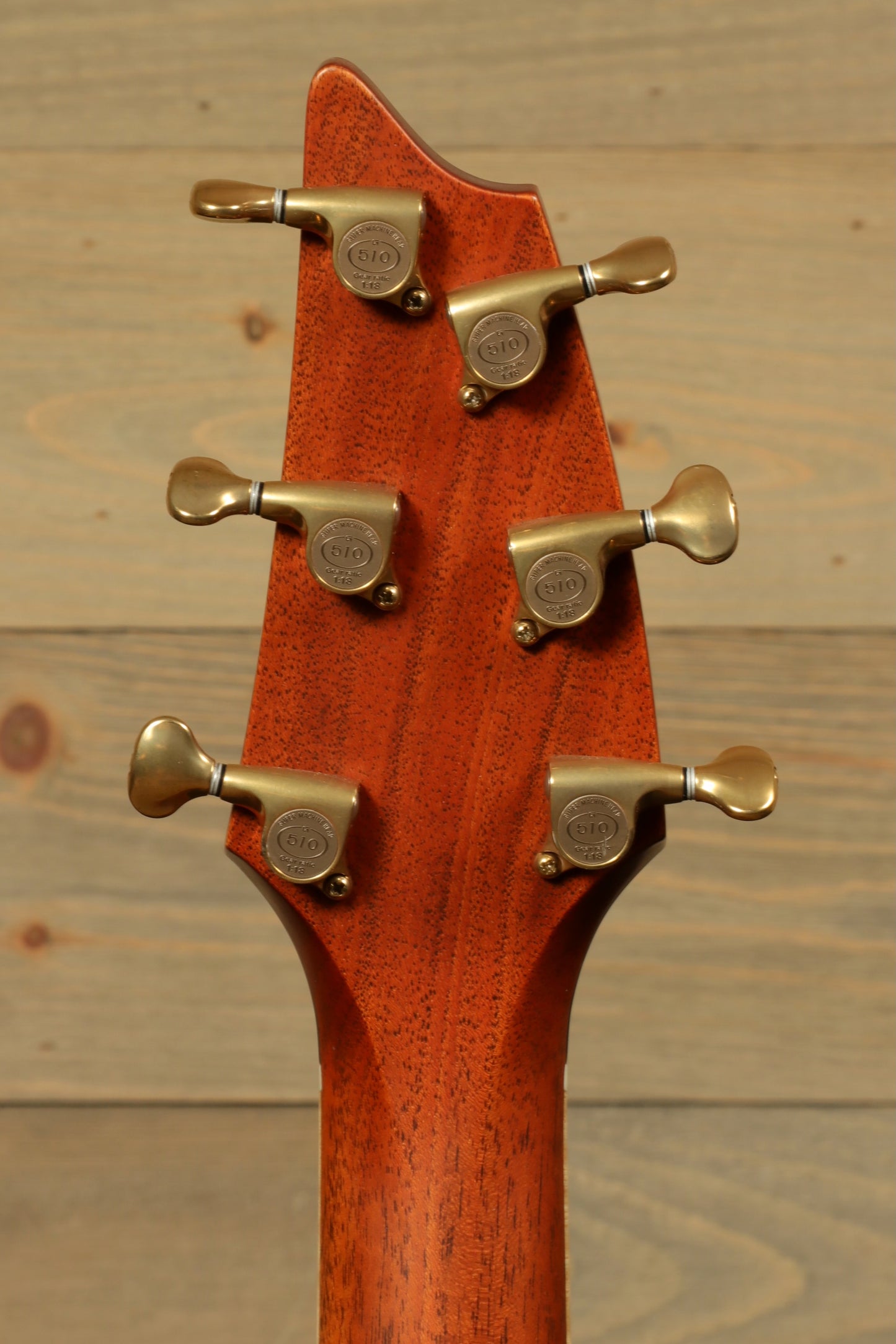 Close-up of the headstock of a used Breedlove Masterclass Concert guitar with golden tuning pegs