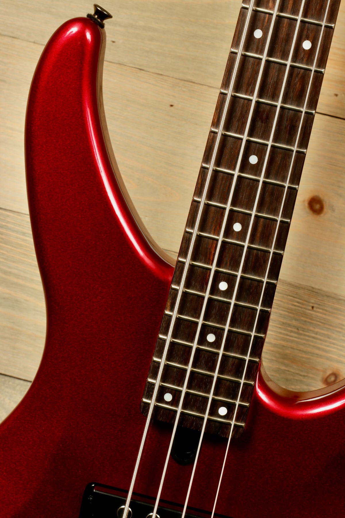 Yamaha electric bass and guitar in glossy red finish, top view showcasing the fretboard and body