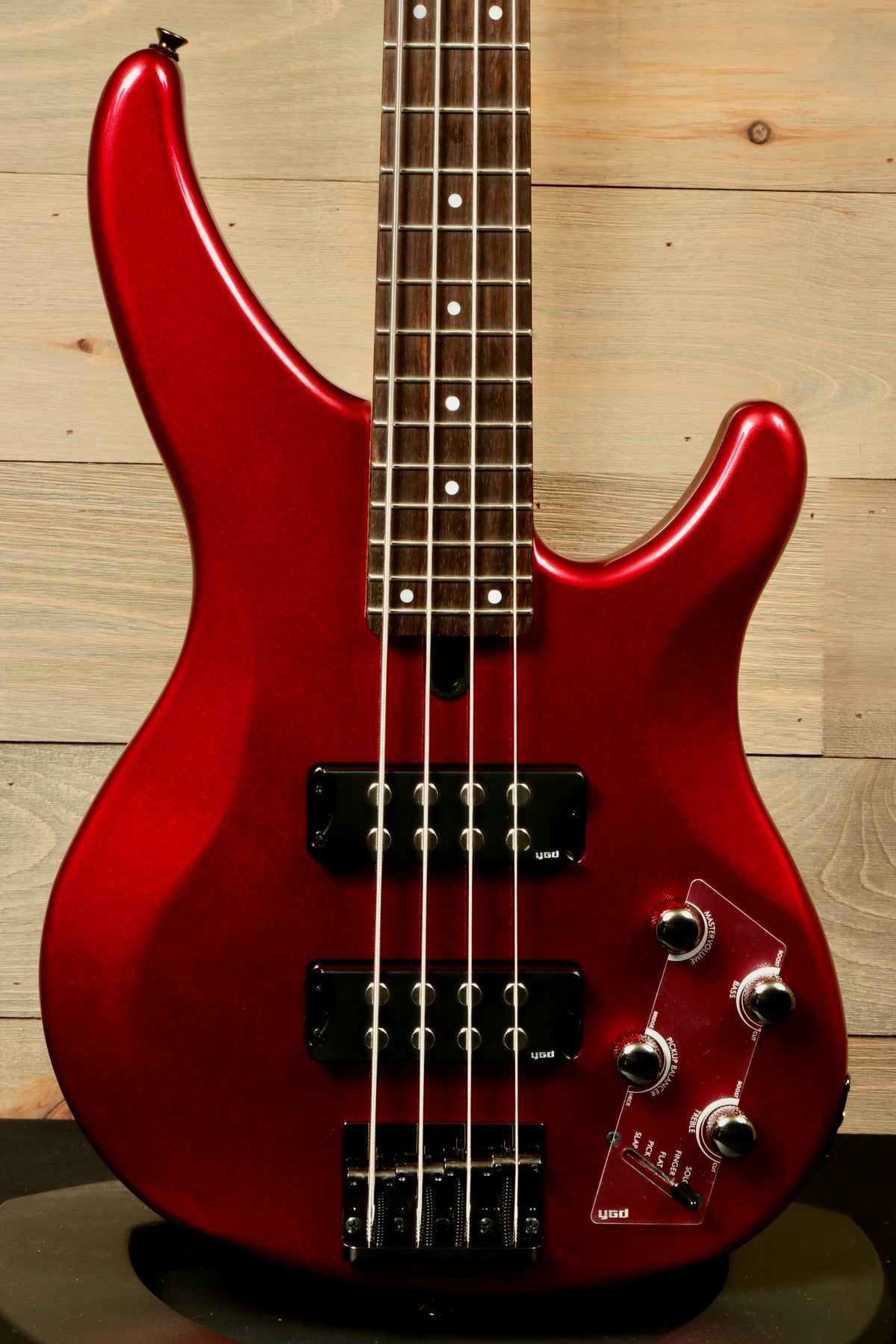 Yamaha electric bass and guitar in red metallic finish, front view, showcasing bass body and controls