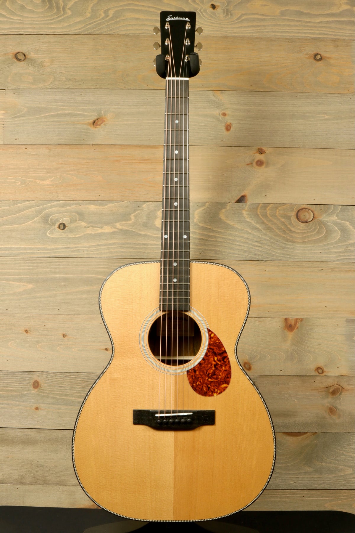 Front view of the Eastman E3OME acoustic guitar, featuring its elegant design and detailed neck, solid Sitka spruce top, and ornate rosette.