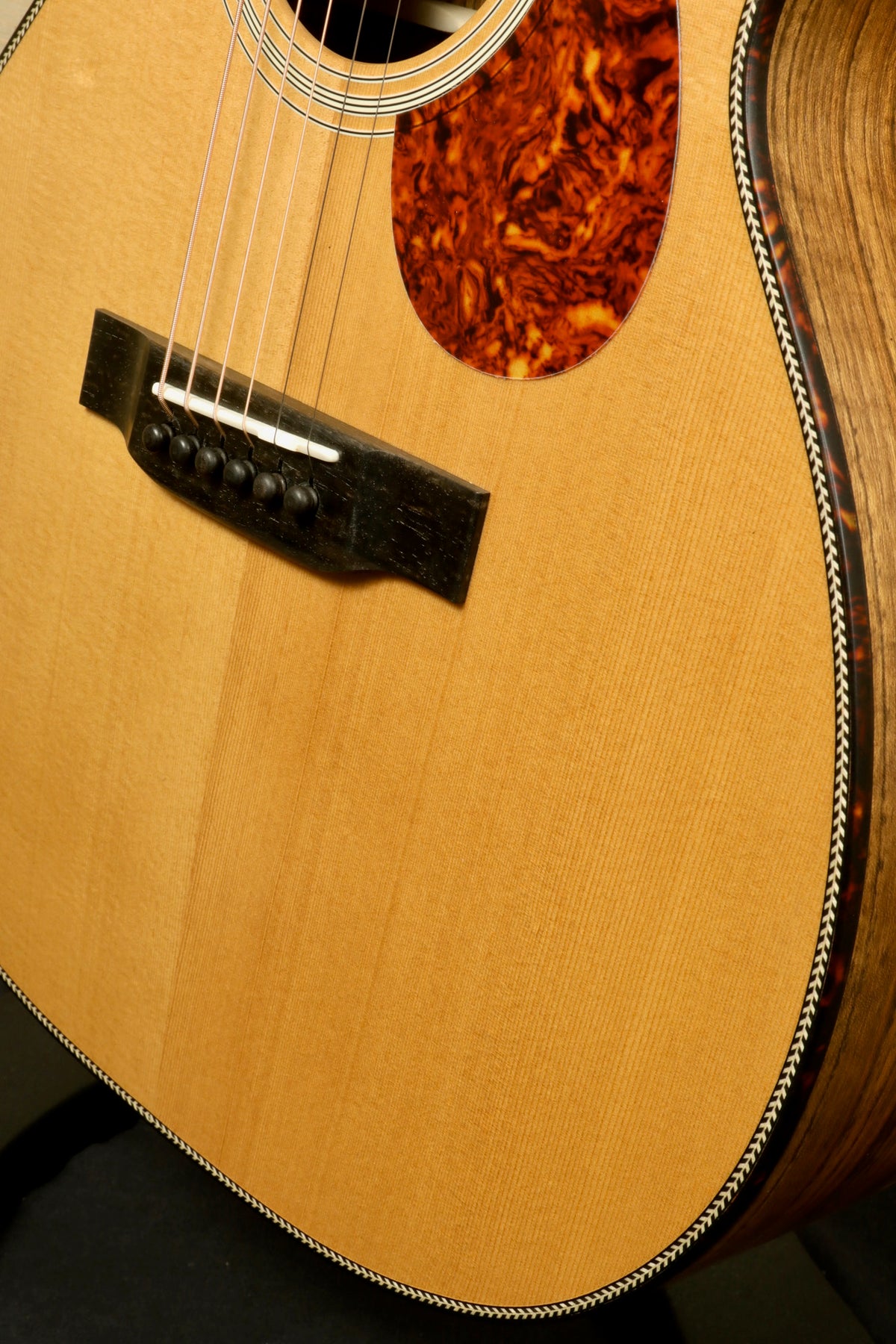 Detailed close-up of the Eastman E3OME acoustic guitar's pickguard and sound hole, emphasizing the craftsmanship and quality materials.