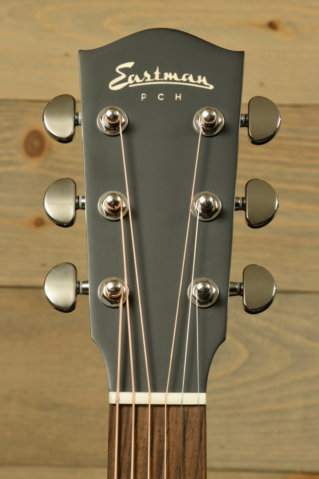 Eastman PCH2-OM-CLA acoustic guitar headstock in dark finish, front view
