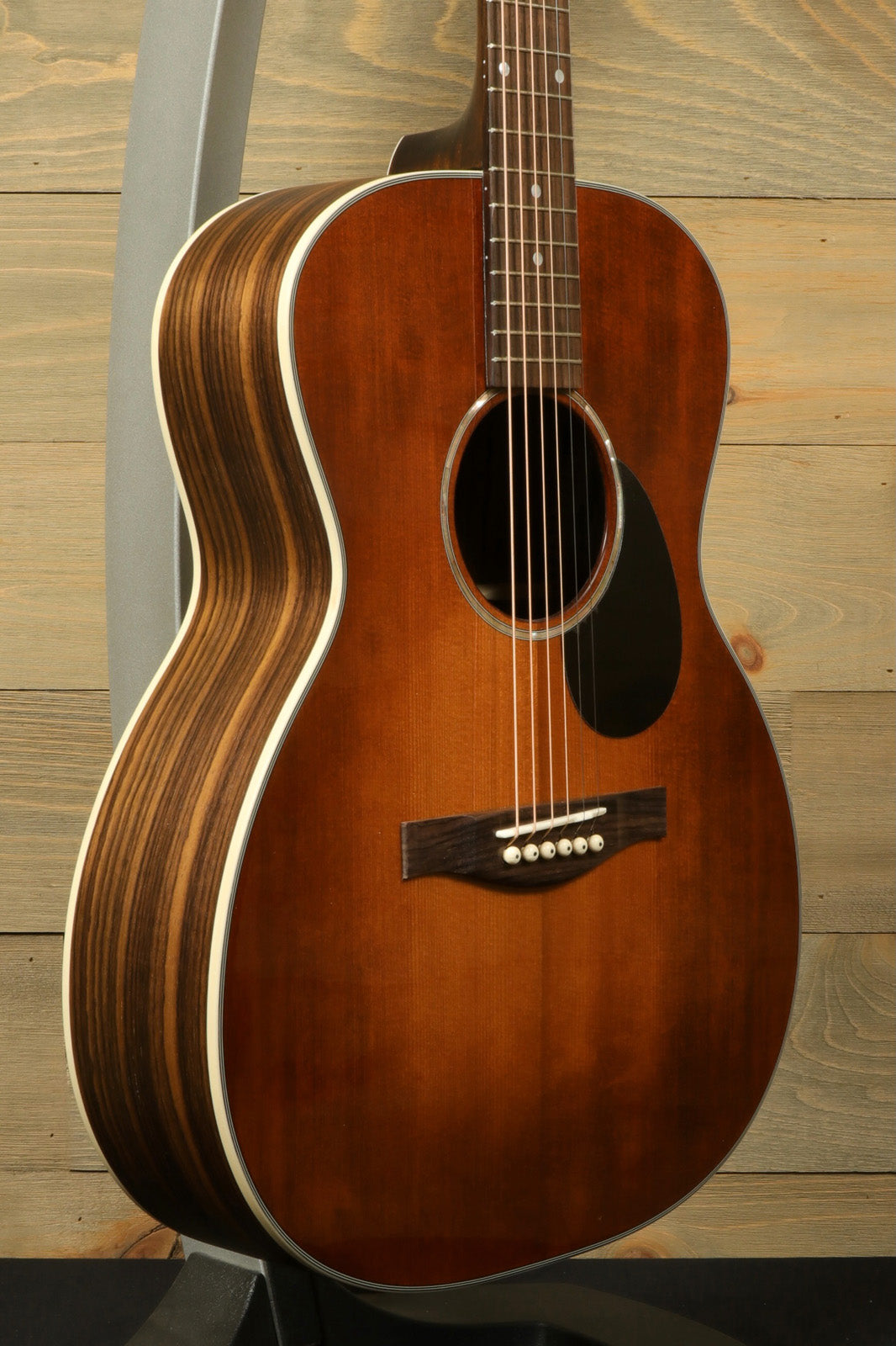 Eastman PCH2-OM-CLA acoustic guitar in natural finish, side view highlighting craftsmanship