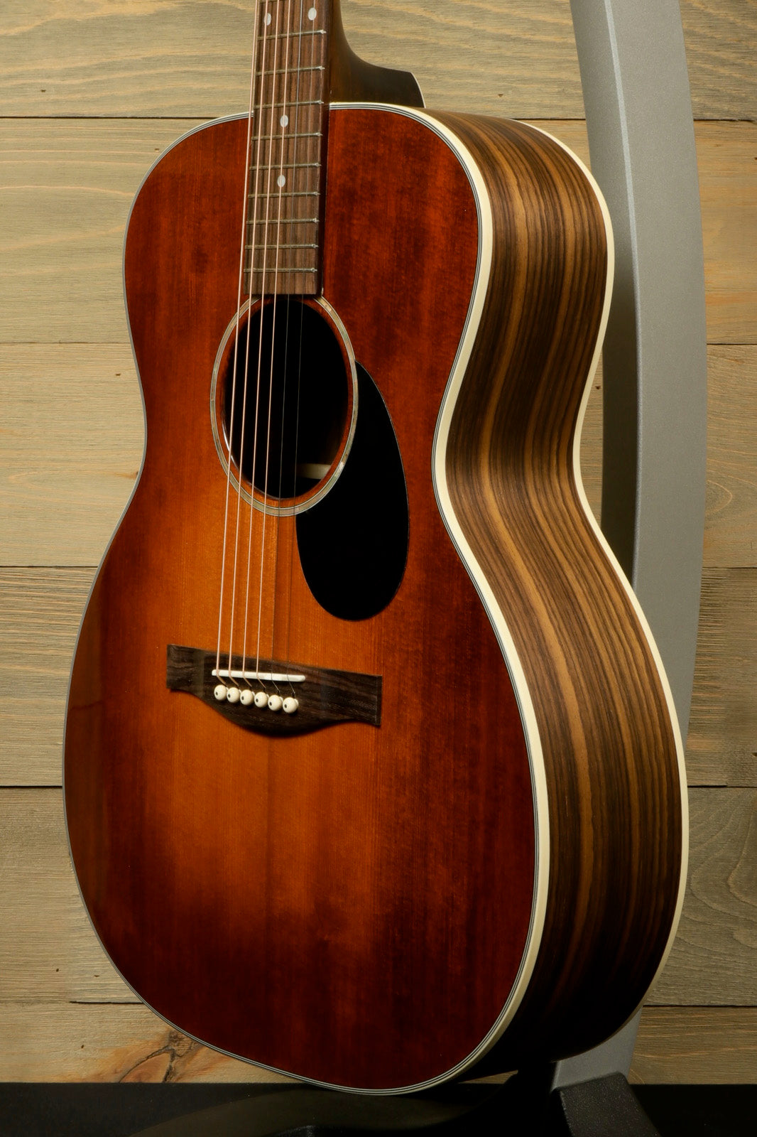 Eastman PCH2-OM-CLA acoustic guitar in sunburst finish, side view showcasing elegant wood grain