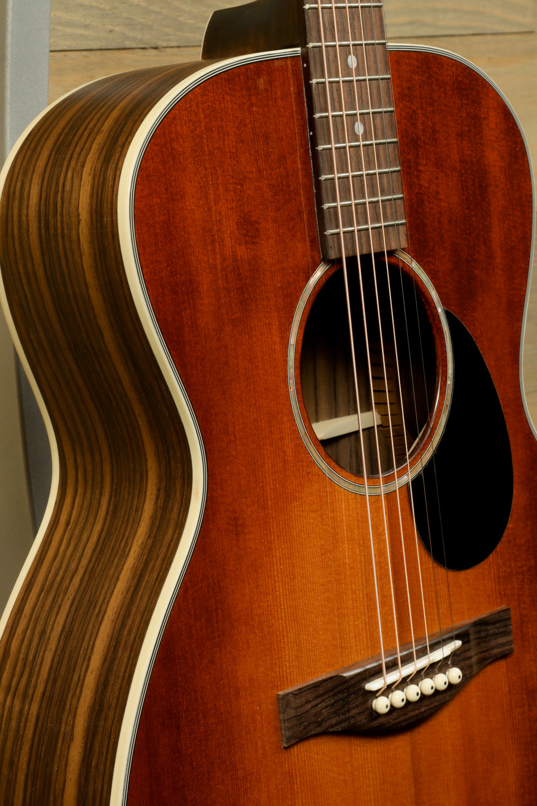 Eastman PCH2-OM-CLA acoustic guitar with rich brown finish, side view highlighting craftsmanship