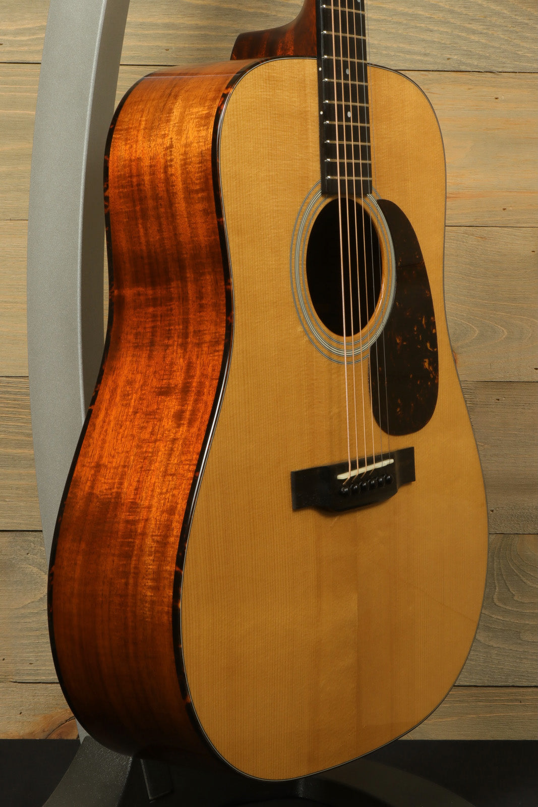 Eastman E10D-TC acoustic electric guitar with natural finish, side view, showcasing beautiful wood grain