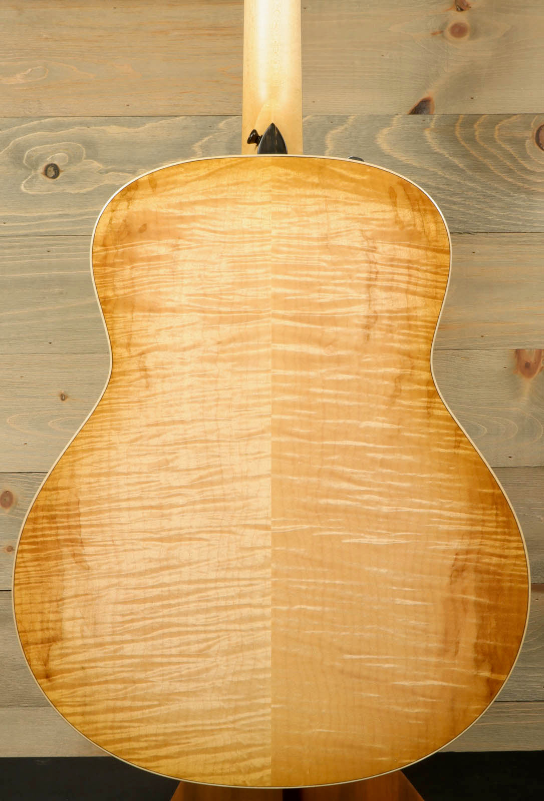 a close up of an acoustic guitar on a stand