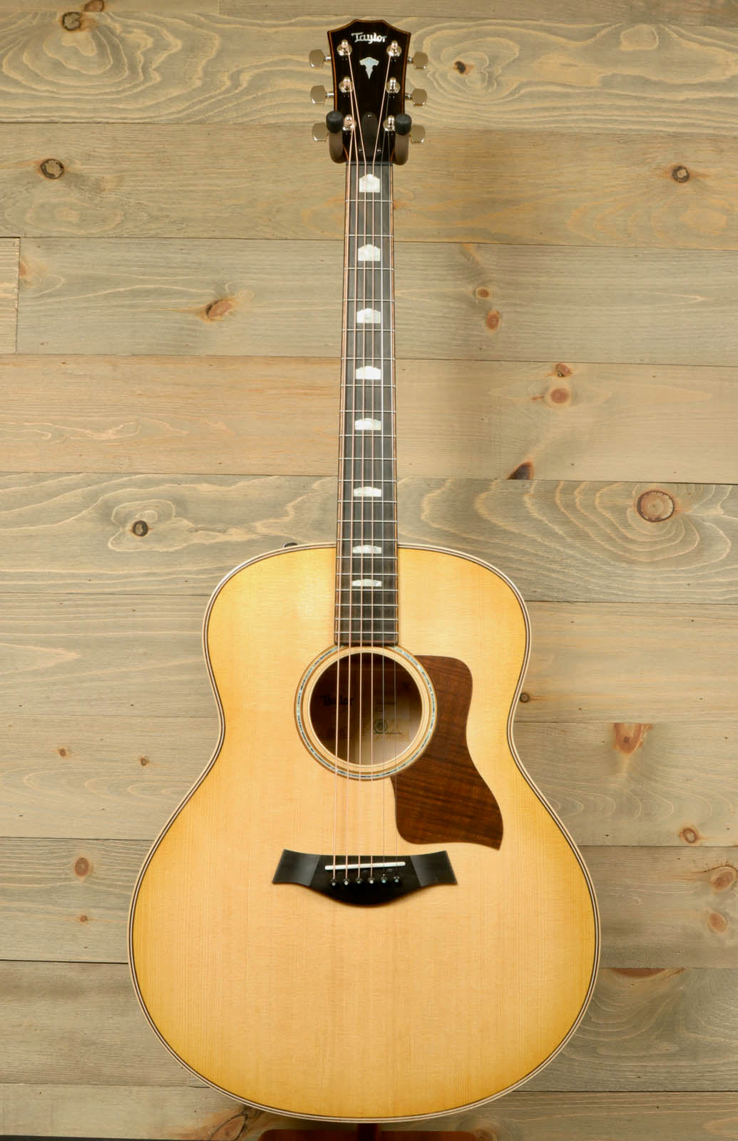 a small acoustic guitar sitting on top of a wooden table