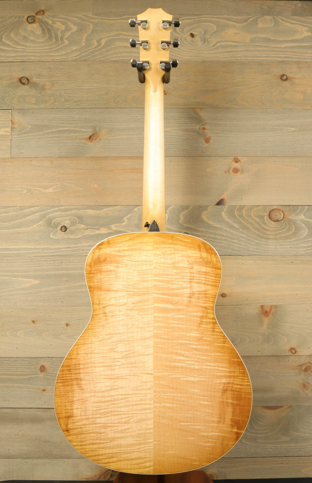 a wooden guitar sitting on top of a wooden floor