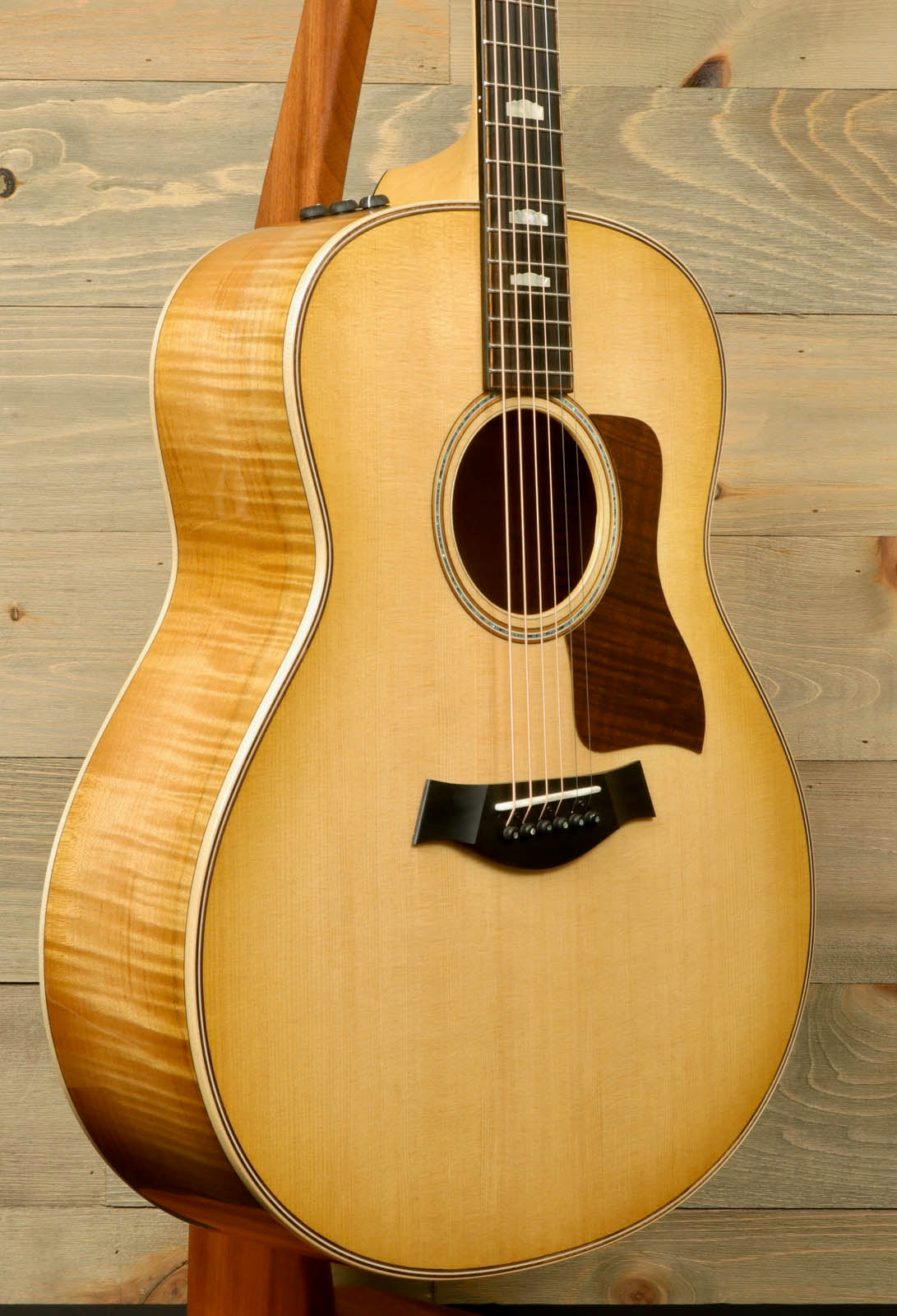 a wooden guitar hanging on a wooden wall