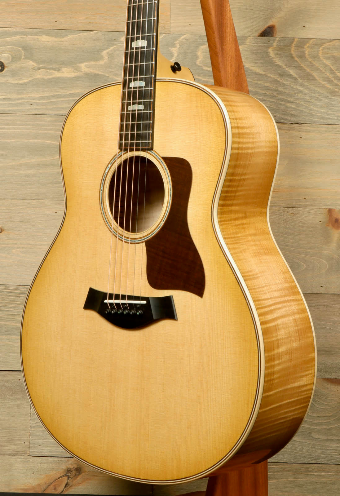 a wooden guitar hanging on a wooden wall