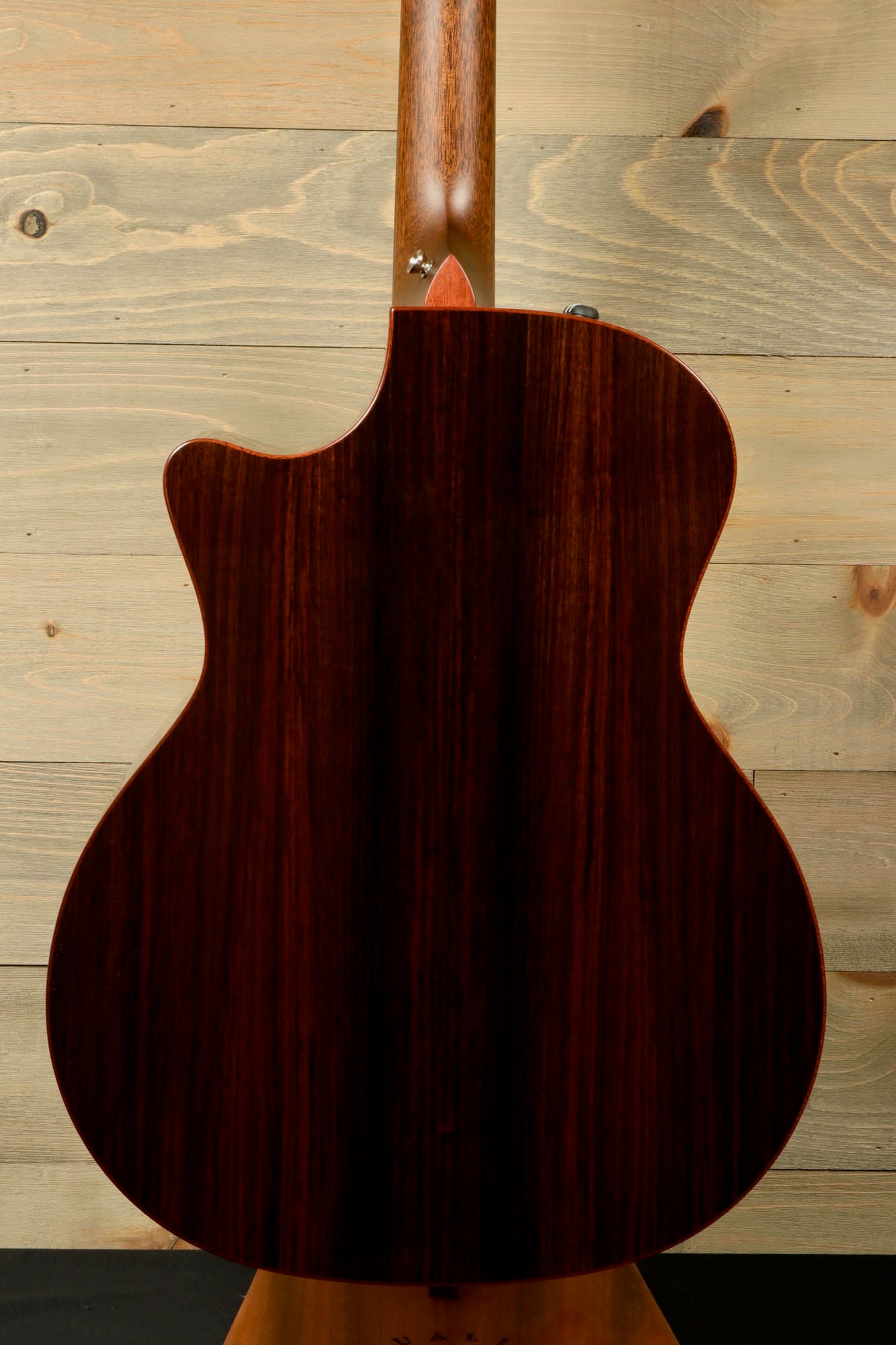 a close up of an acoustic guitar on a stand