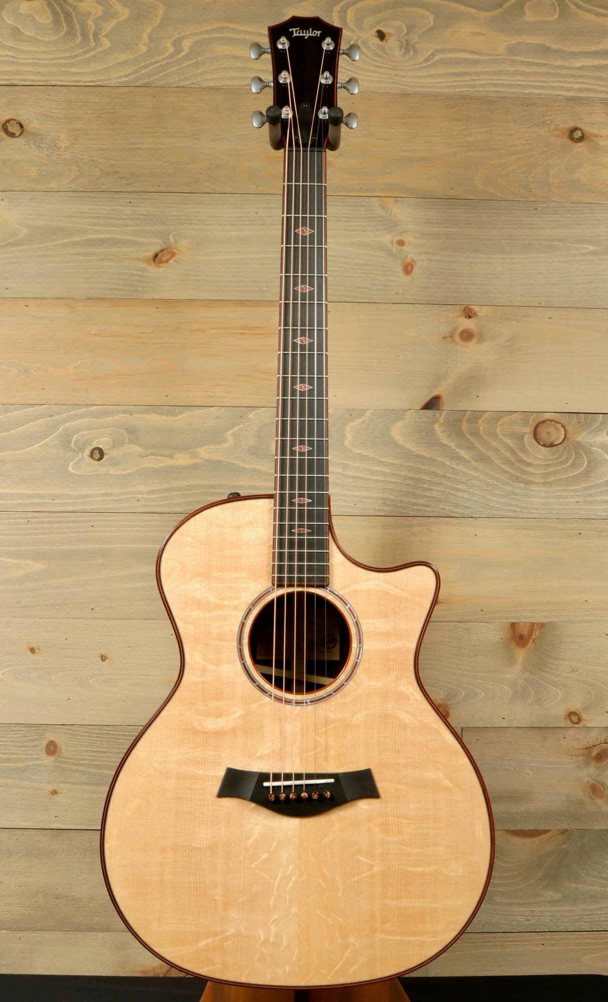 a wooden guitar sitting on top of a wooden stand