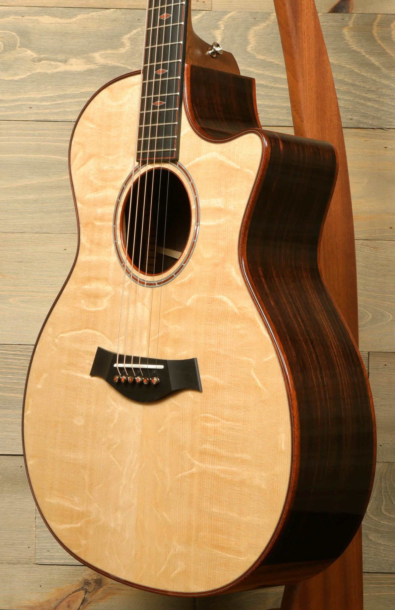 a wooden guitar hanging on a wooden wall