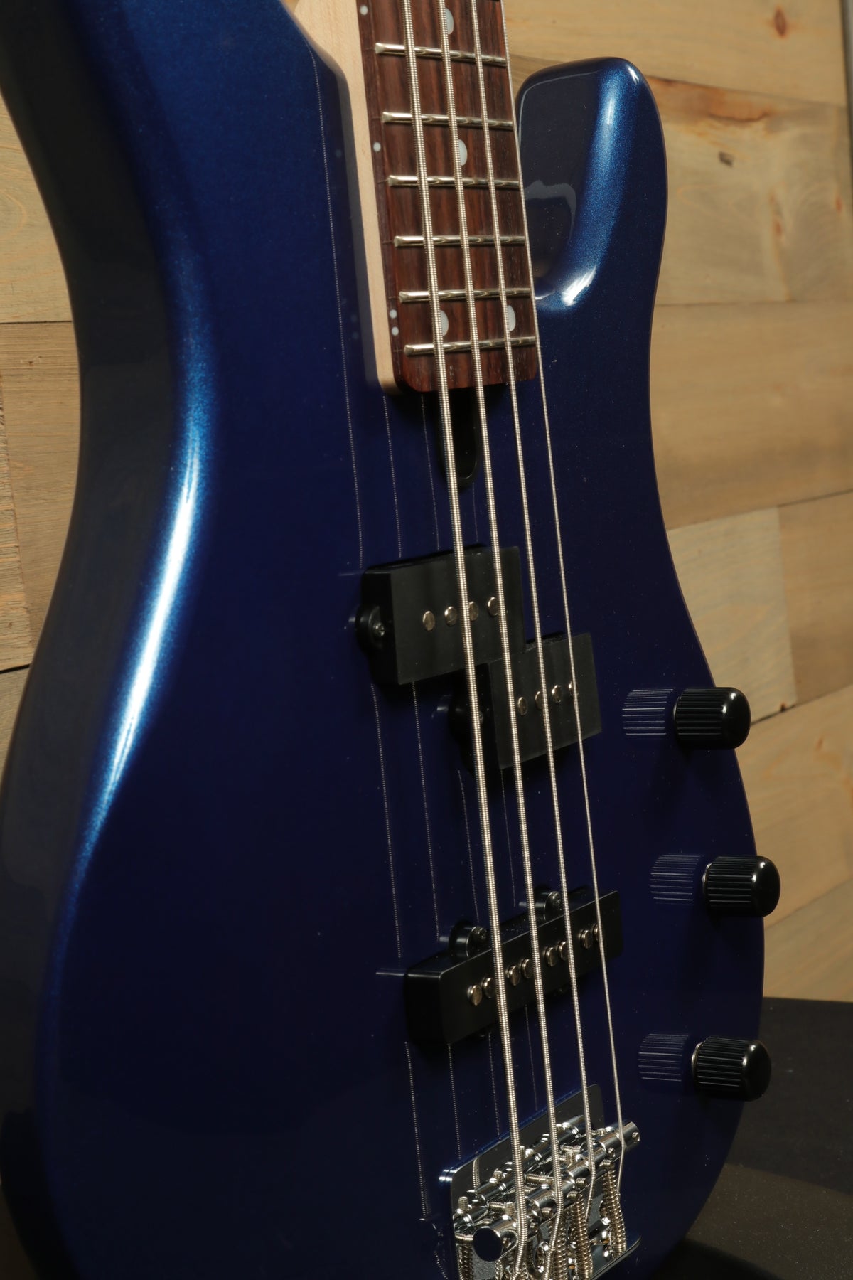 Yamaha TRBX174 electric bass guitar in blue finish, side view showcasing the body and controls