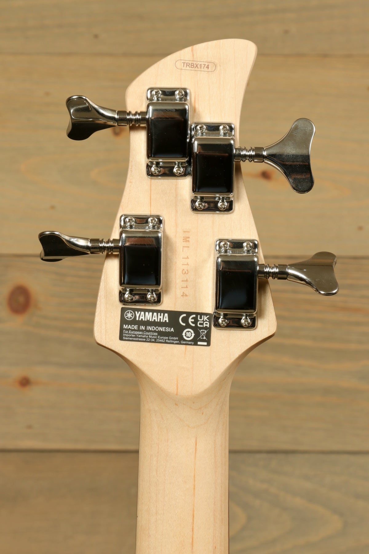 Yamaha TRBX174 bass guitar headstock view with tuning pegs, natural wood finish