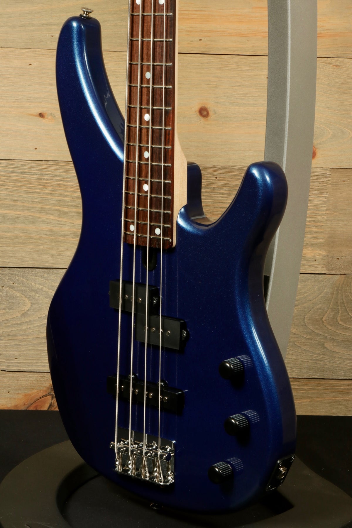 Yamaha TRBX174 bass guitar in blue metallic finish, side view showcasing sleek design and hardware