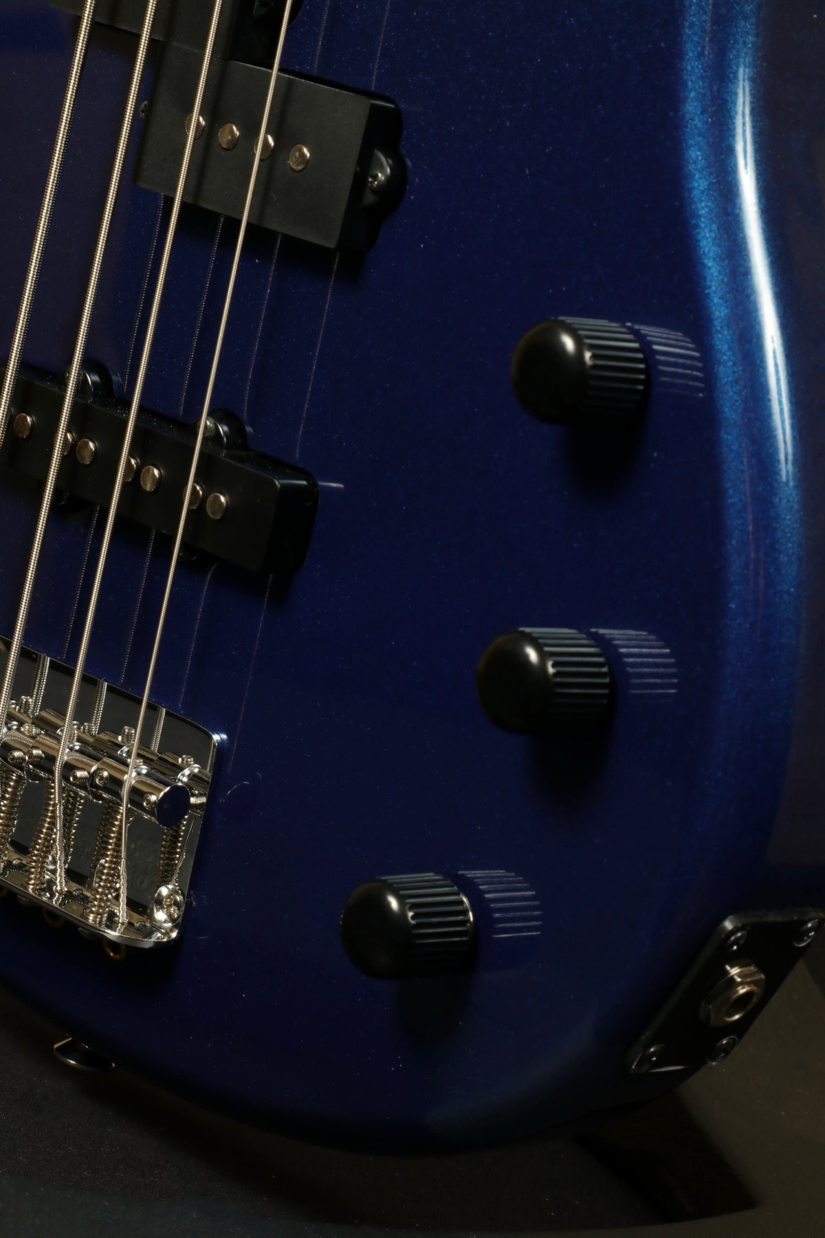Yamaha TRBX174 bass guitar in blue finish, side view showcasing control knobs and hardware