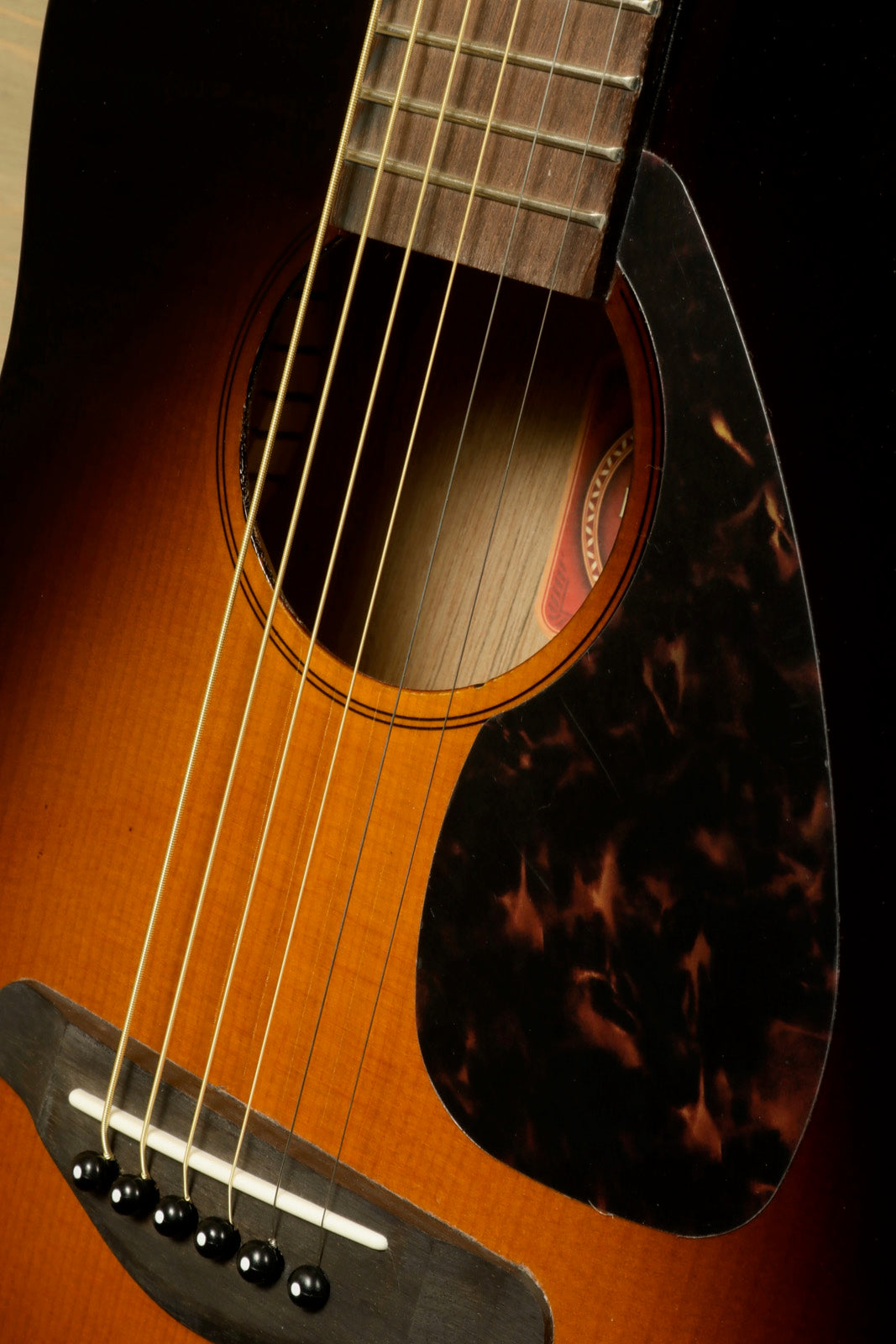Yamaha acoustic guitar with sunburst finish, close-up view showcasing soundhole and strings