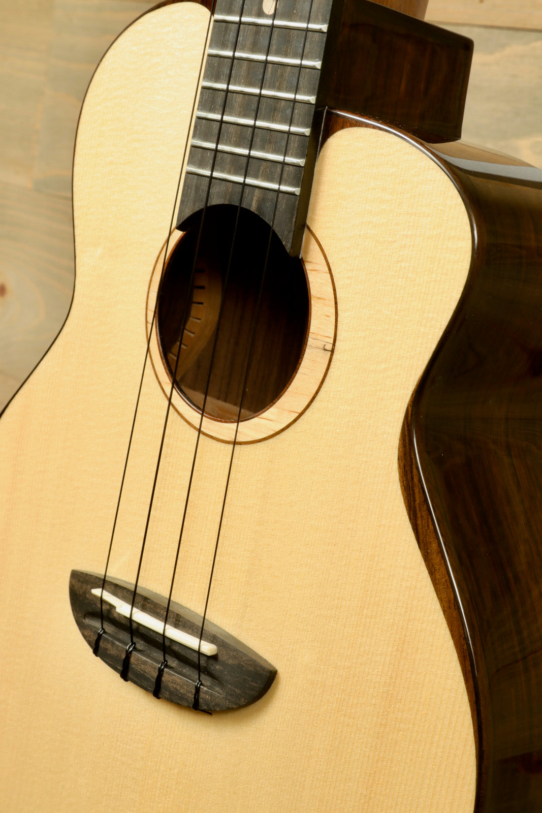 ANueNue UT200 ukulele with natural wood finish, a close-up view of the body and neck