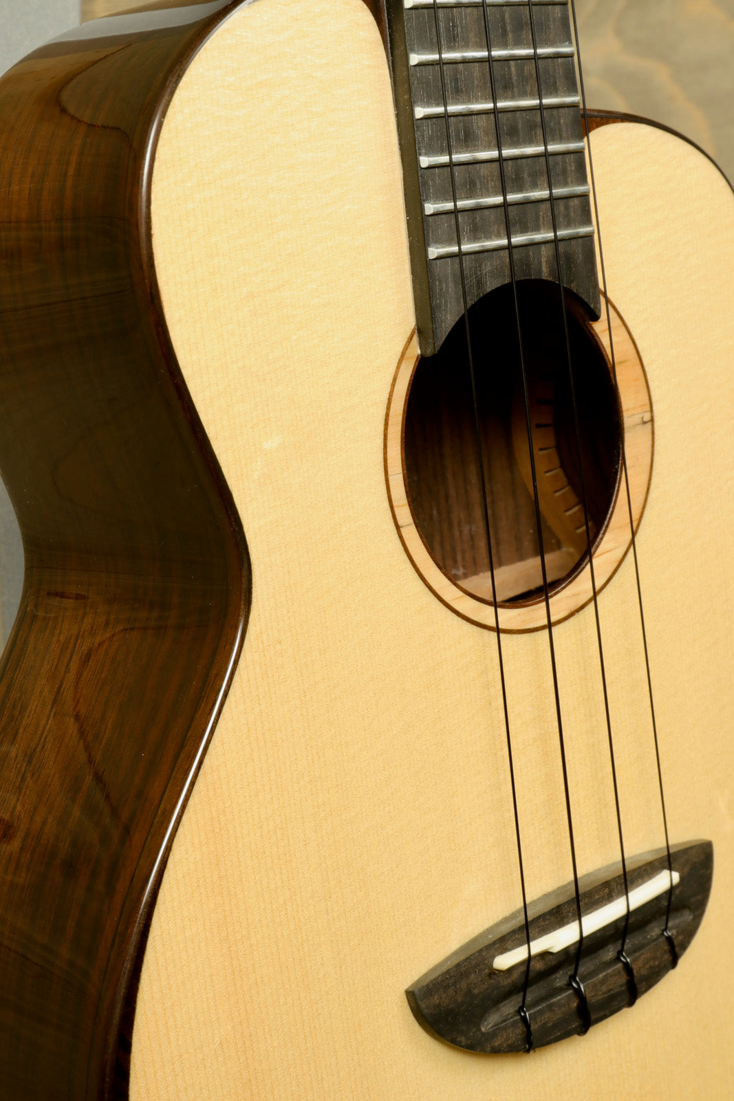 ANueNue UT200 ukulele in natural wood finish, close-up view showing body and strings