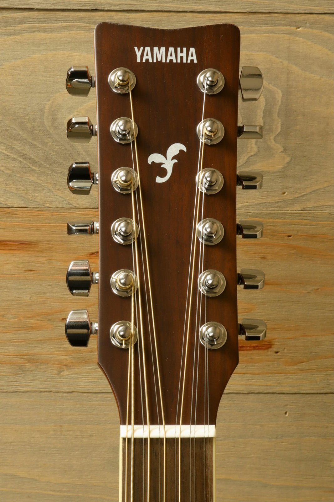 Yamaha acoustic guitar acoustic guitar with a brown headstock and silver tuning pegs, front view