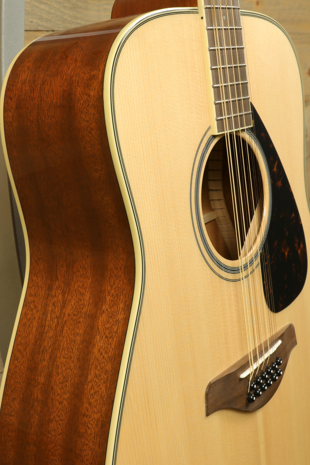 Yamaha acoustic guitar, natural finish, side view showcasing body and strings