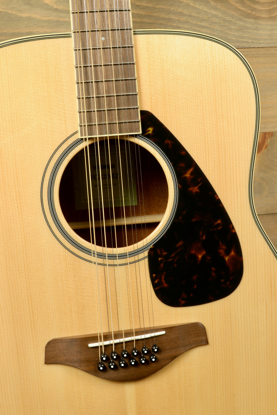 Yamaha acoustic guitar with natural wood finish and tortoiseshell pickguard, front view