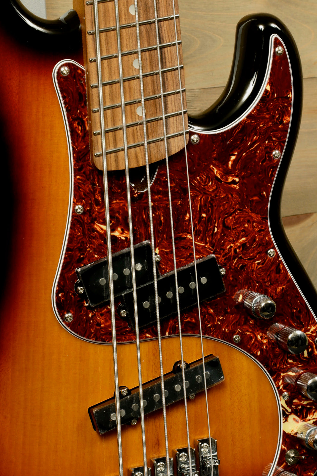Tagima bass guitar 5 string, sunburst finish with a tortoiseshell pickguard, close-up view