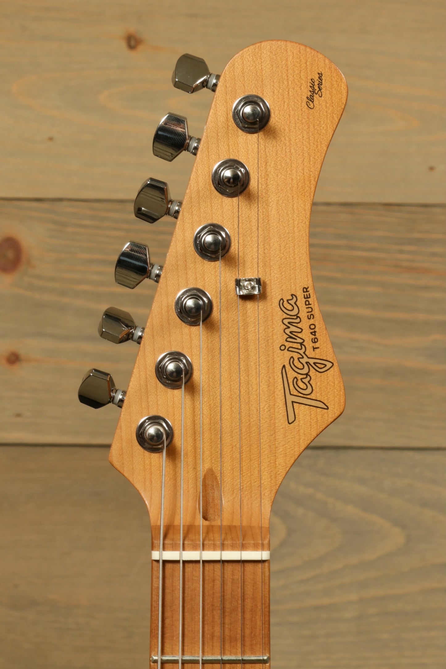 Tagima electric guitar guitars headstock view, featuring vintage style tuners and natural wood finish