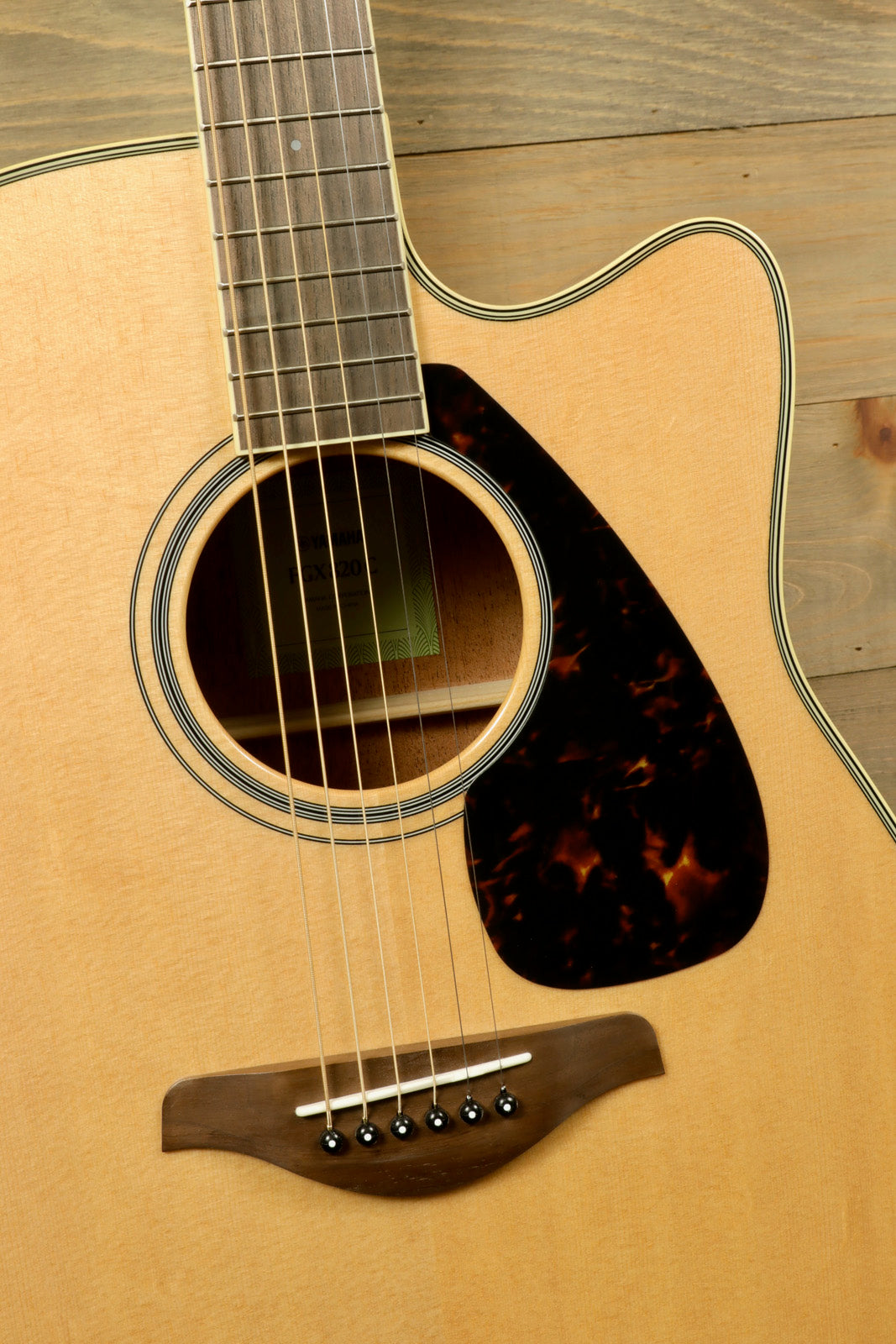 Yamaha Acoustic Electric Guitar, natural finish, front view showcasing wood grain and soundhole