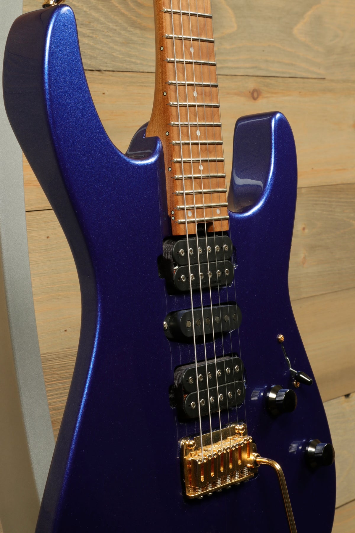 Charvel Pro-Mod DK24 HSH electric guitar in shimmering blue finish, side view with sleek design details