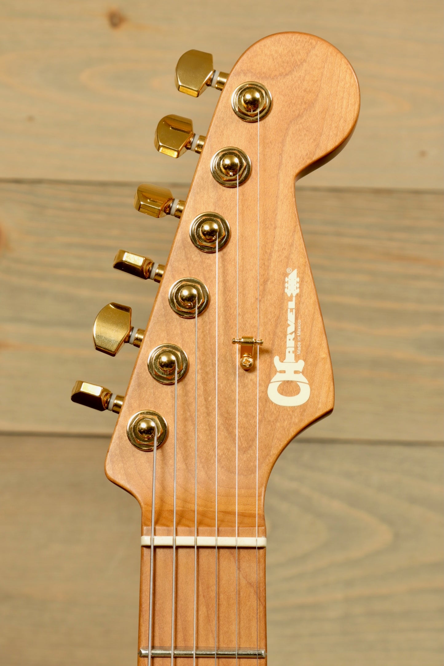 Close-up of Charvel Pro-Mod DK24 Mystic Blue guitar headstock with gold tuning pegs