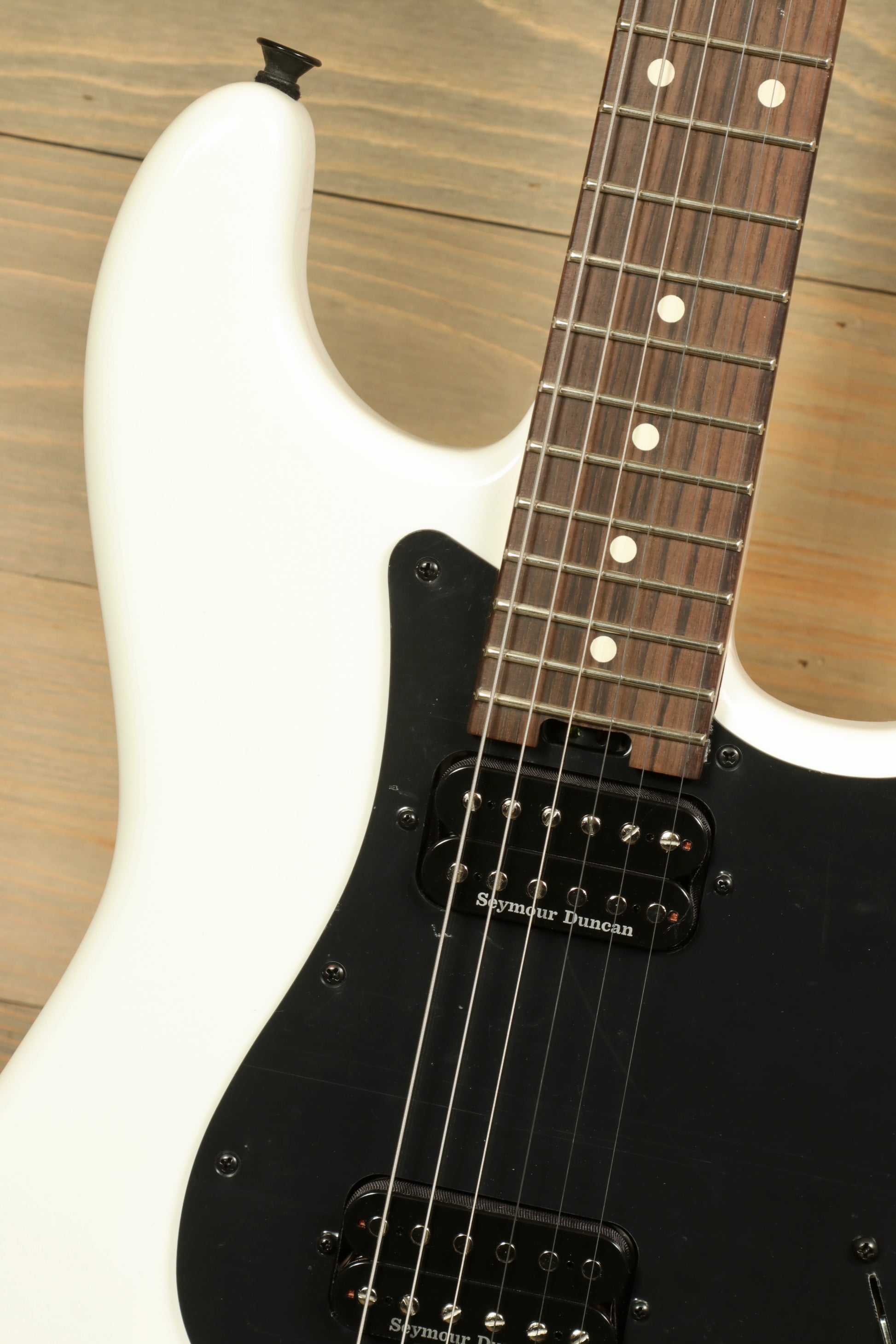 Close-up of Charvel Pro-Mod So-Cal electric guitar with white finish and black hardware