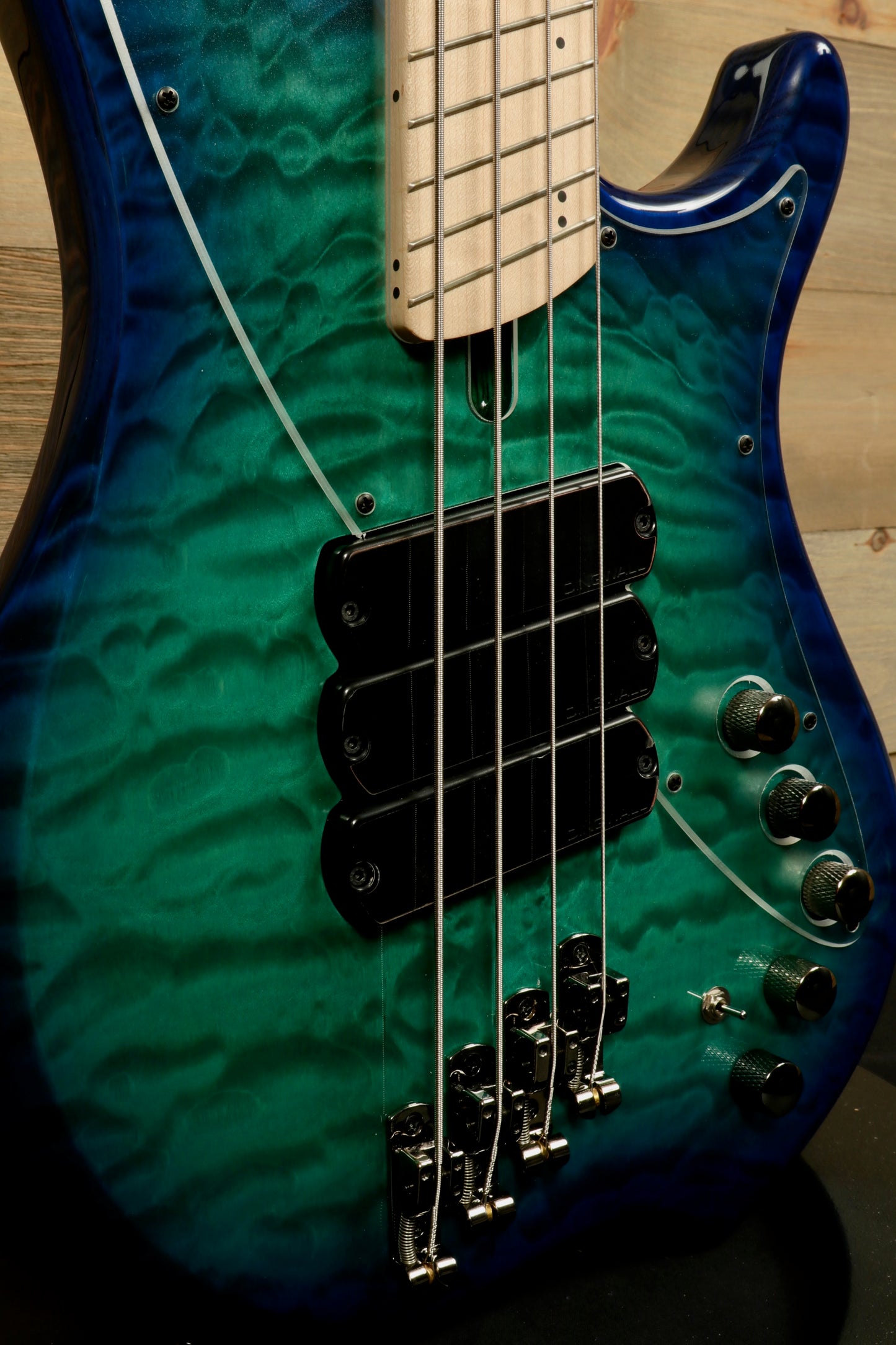 Dingwall Combustion Nashville bass guitar with a blue-green quilted finish, side view showcasing pickups and controls