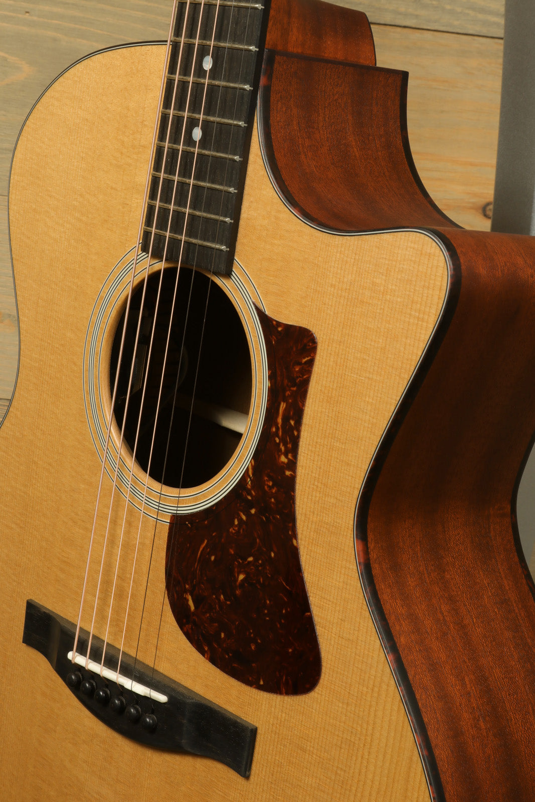 Eastman AC122-1CE acoustic electric guitar with natural finish, side view highlighting curves and wood grain