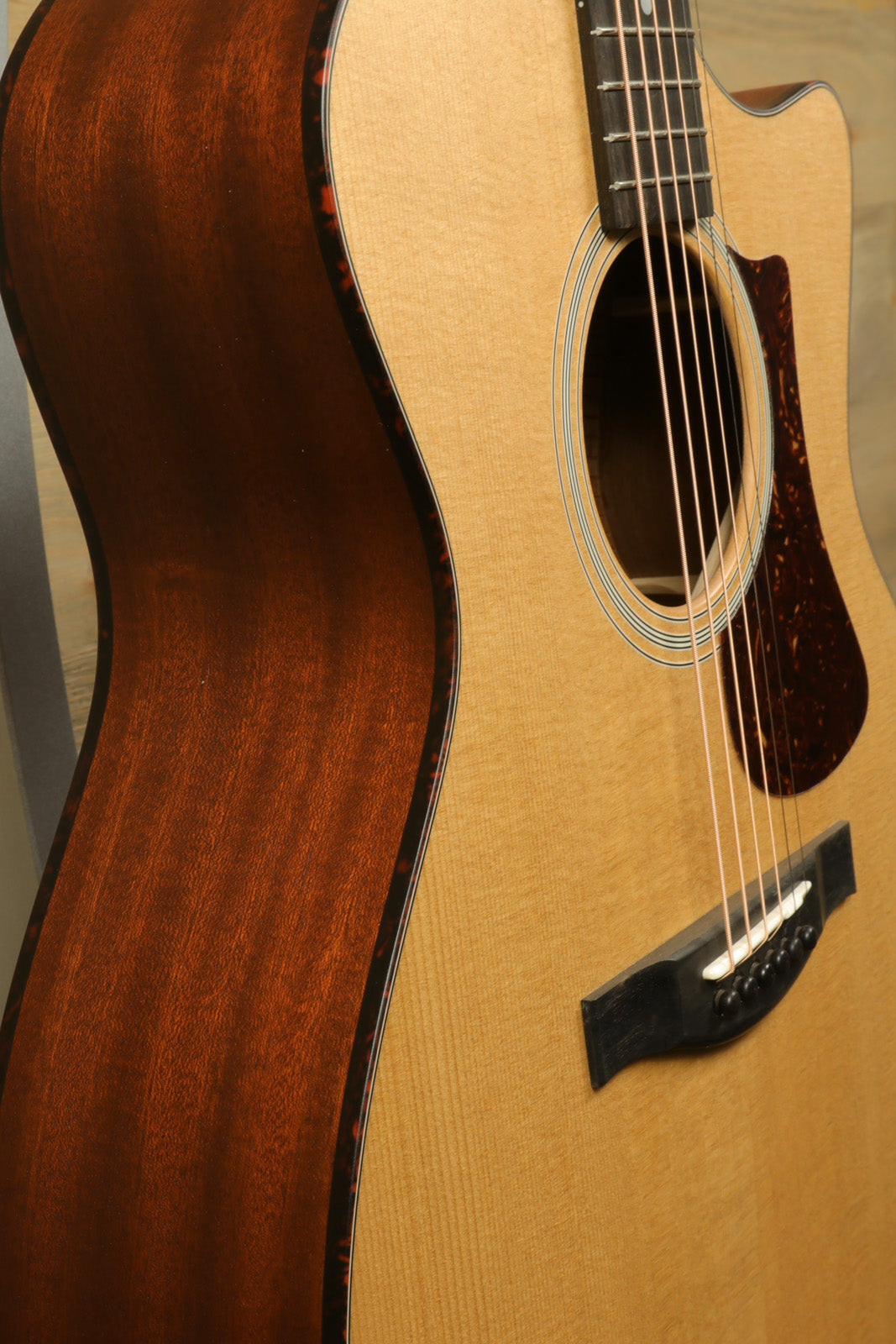 Eastman AC122-1CE acoustic electric guitar in natural finish, side view showcasing the wood grain