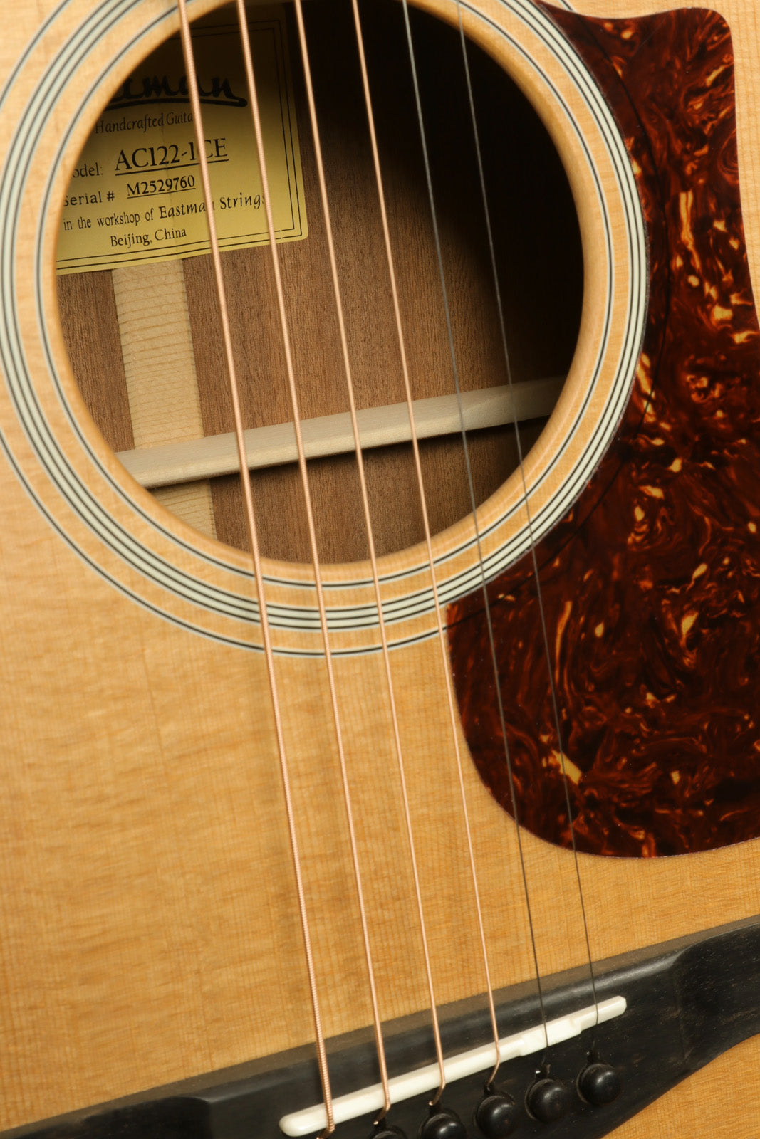 Eastman AC122-1CE acoustic electric guitar, natural finish, close-up of soundhole and strings