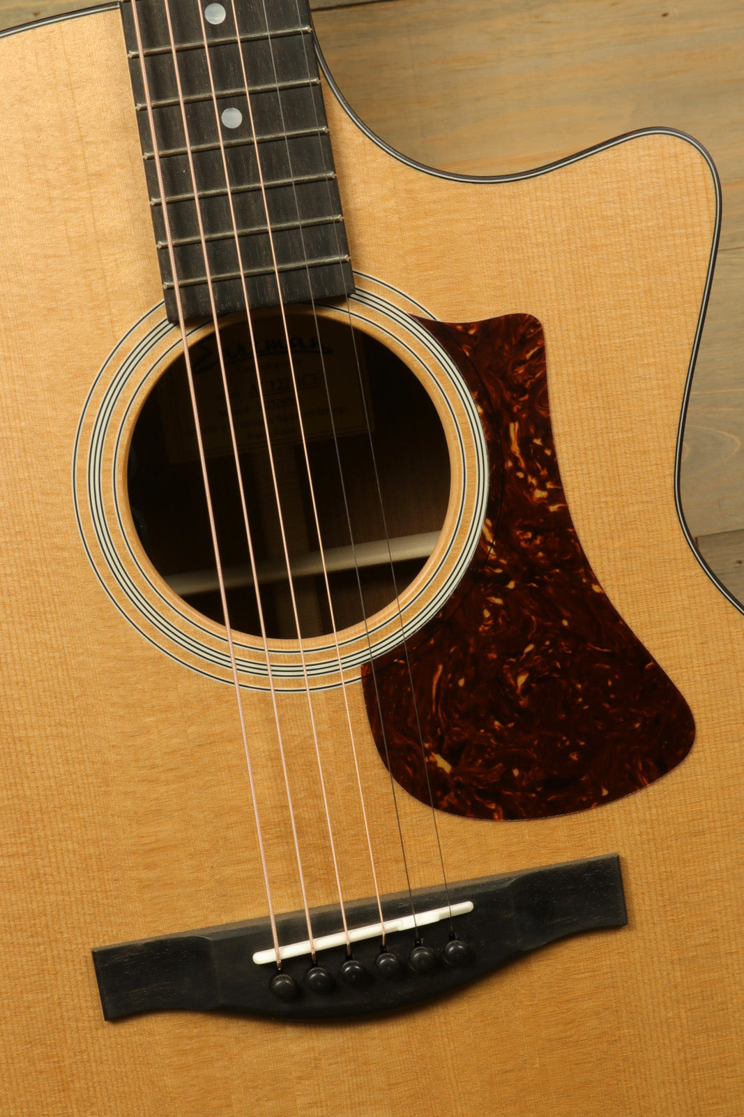 Eastman AC122-1CE acoustic electric guitar, natural finish, top view highlighting the fretboard and soundhole