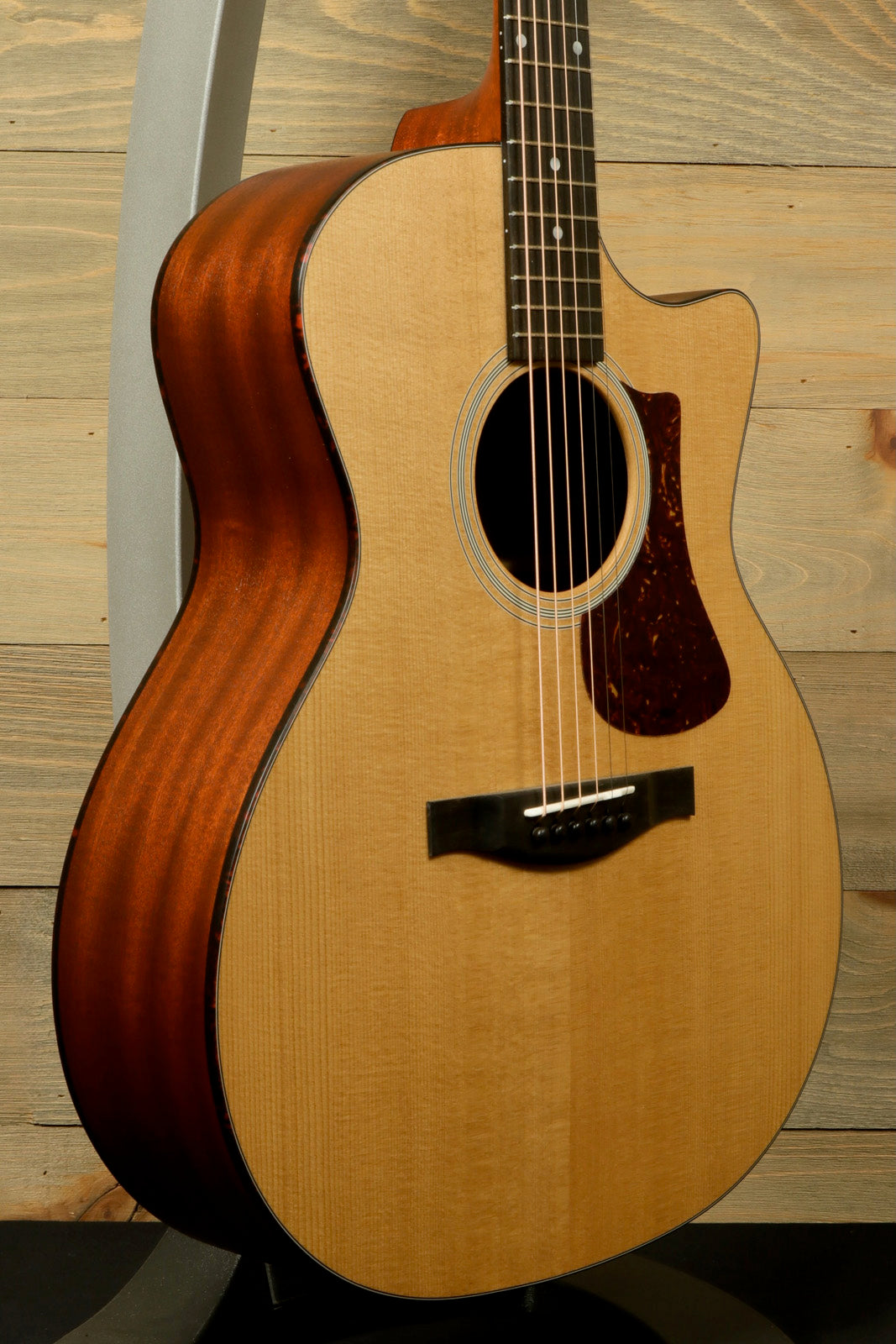 Eastman AC122-1CE acoustic electric guitar with natural finish, side view showcasing wood grain
